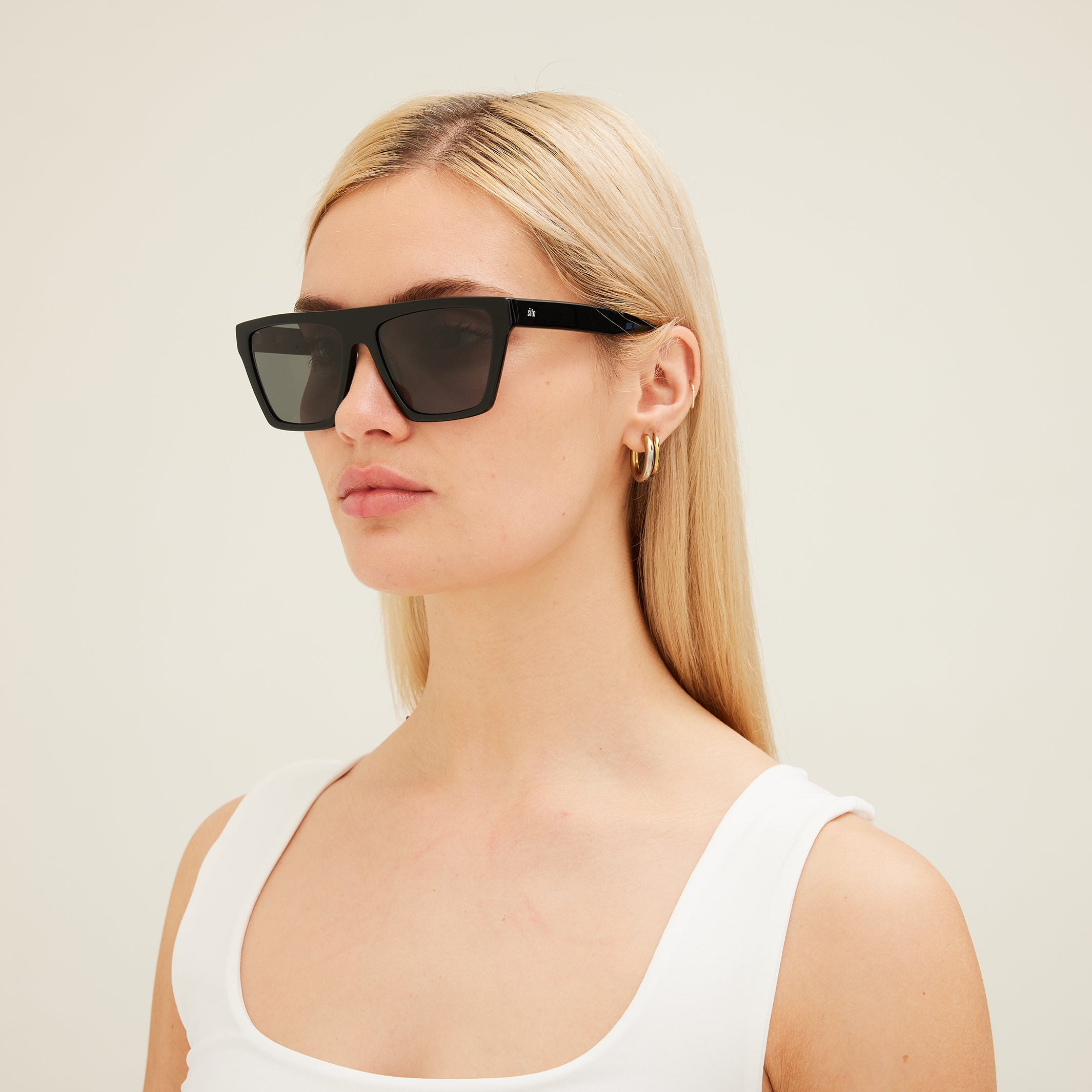 Woman wearing black sunglasses with a plain background