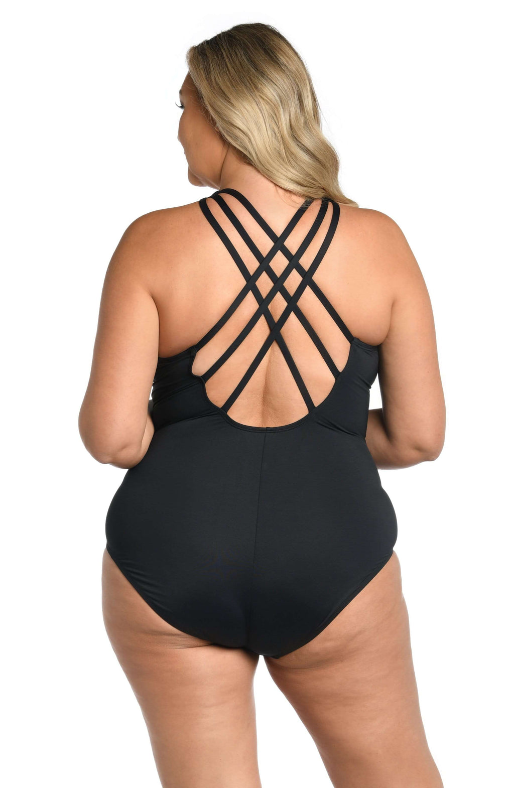 Woman wearing a black one piece swimsuit against a white background. 
