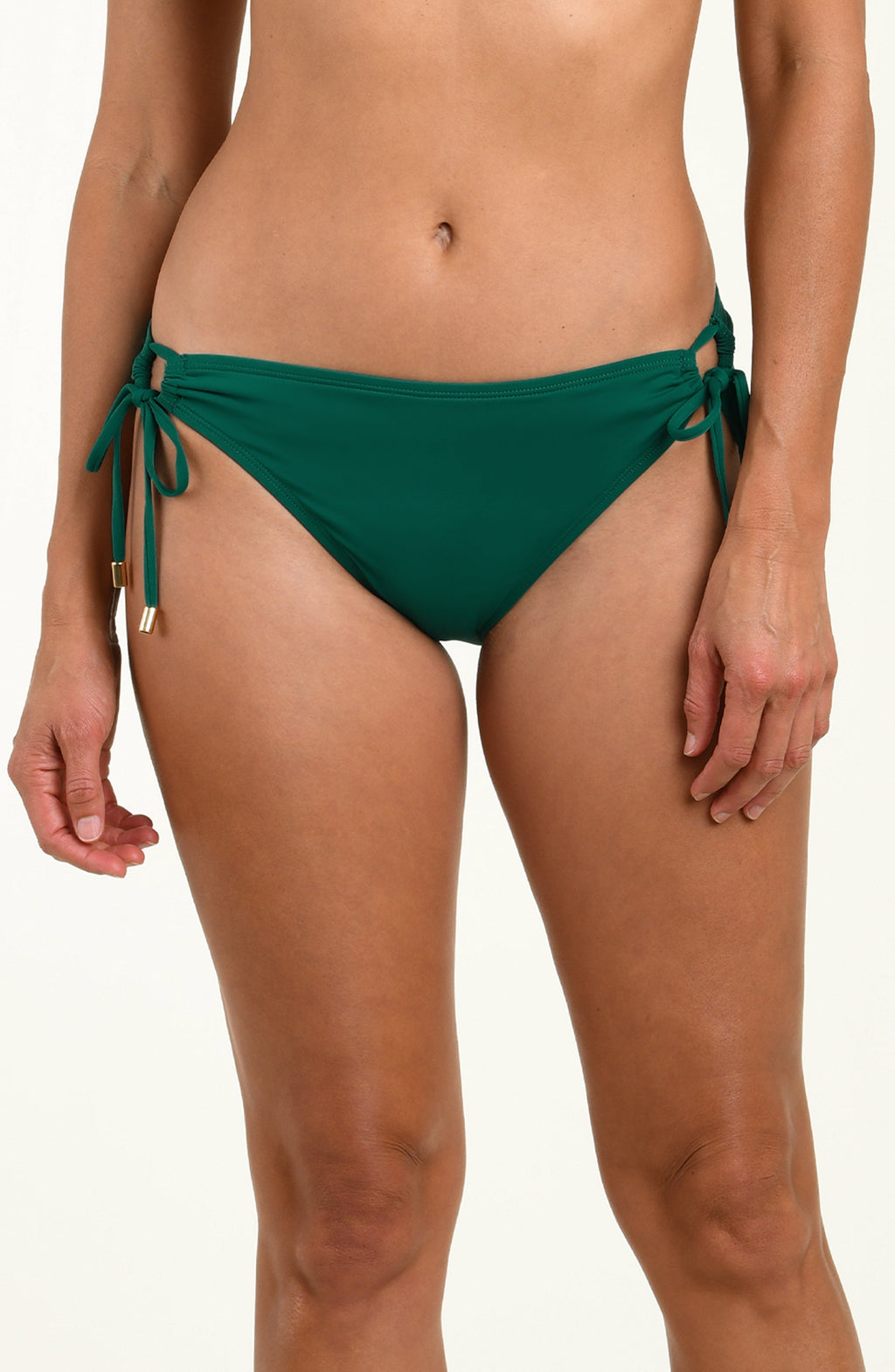 Woman wearing green bikini bottoms against a white background.