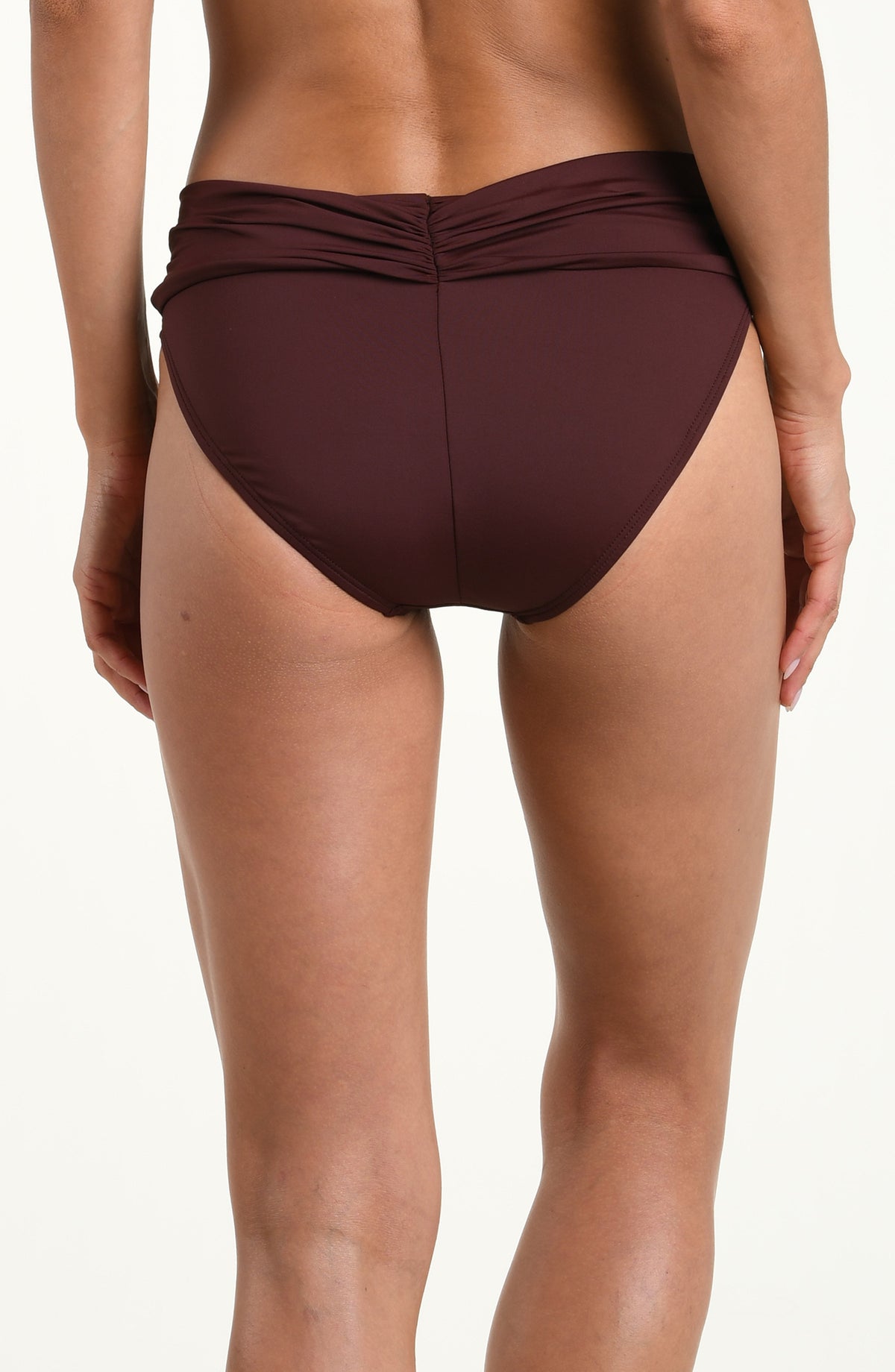 Woman wearing a solid java brown bikini bottom with a front sash against a white background. 