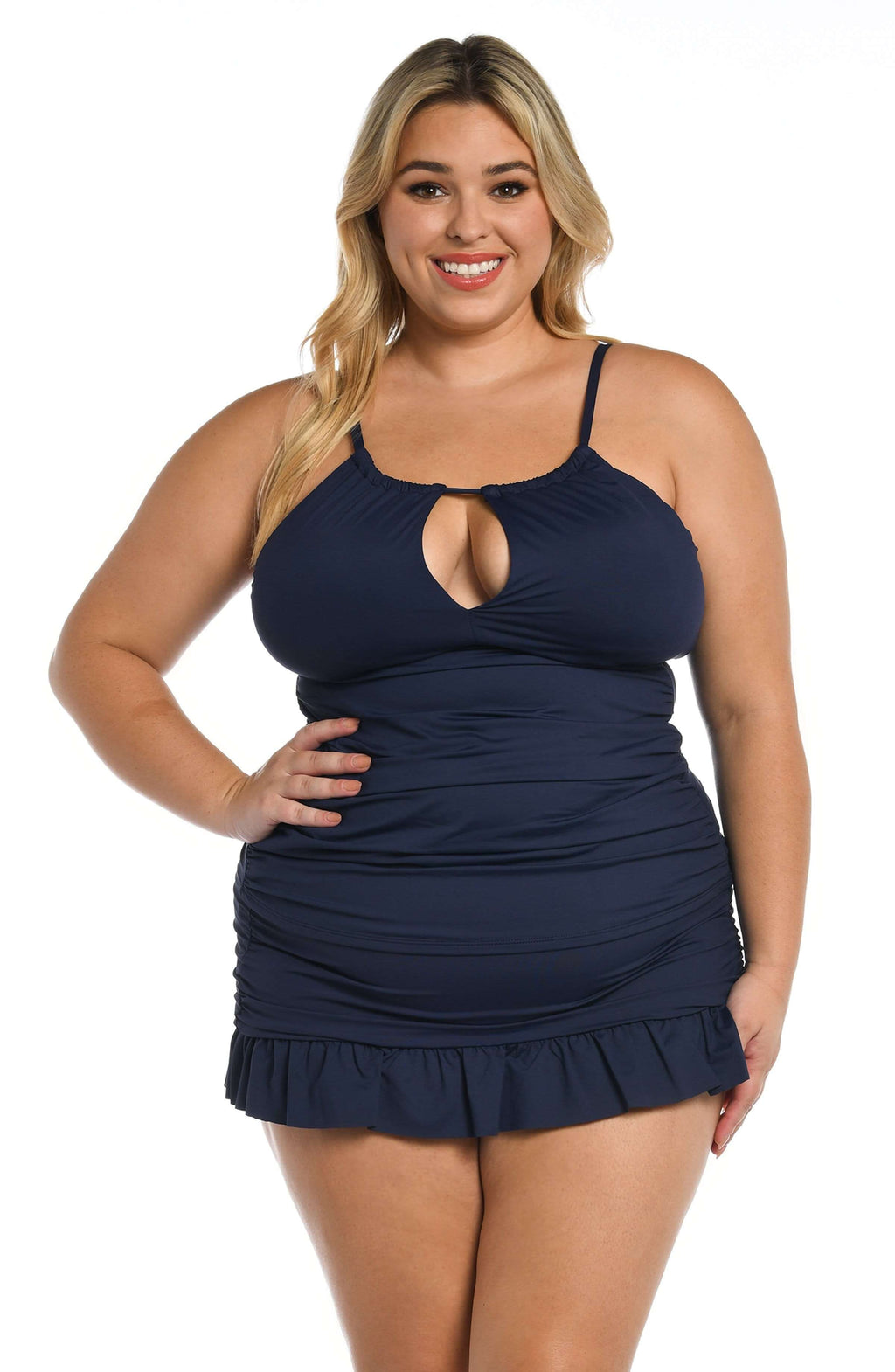 Woman wearing an indigo blue tankini top and matching swim skirt with a white background