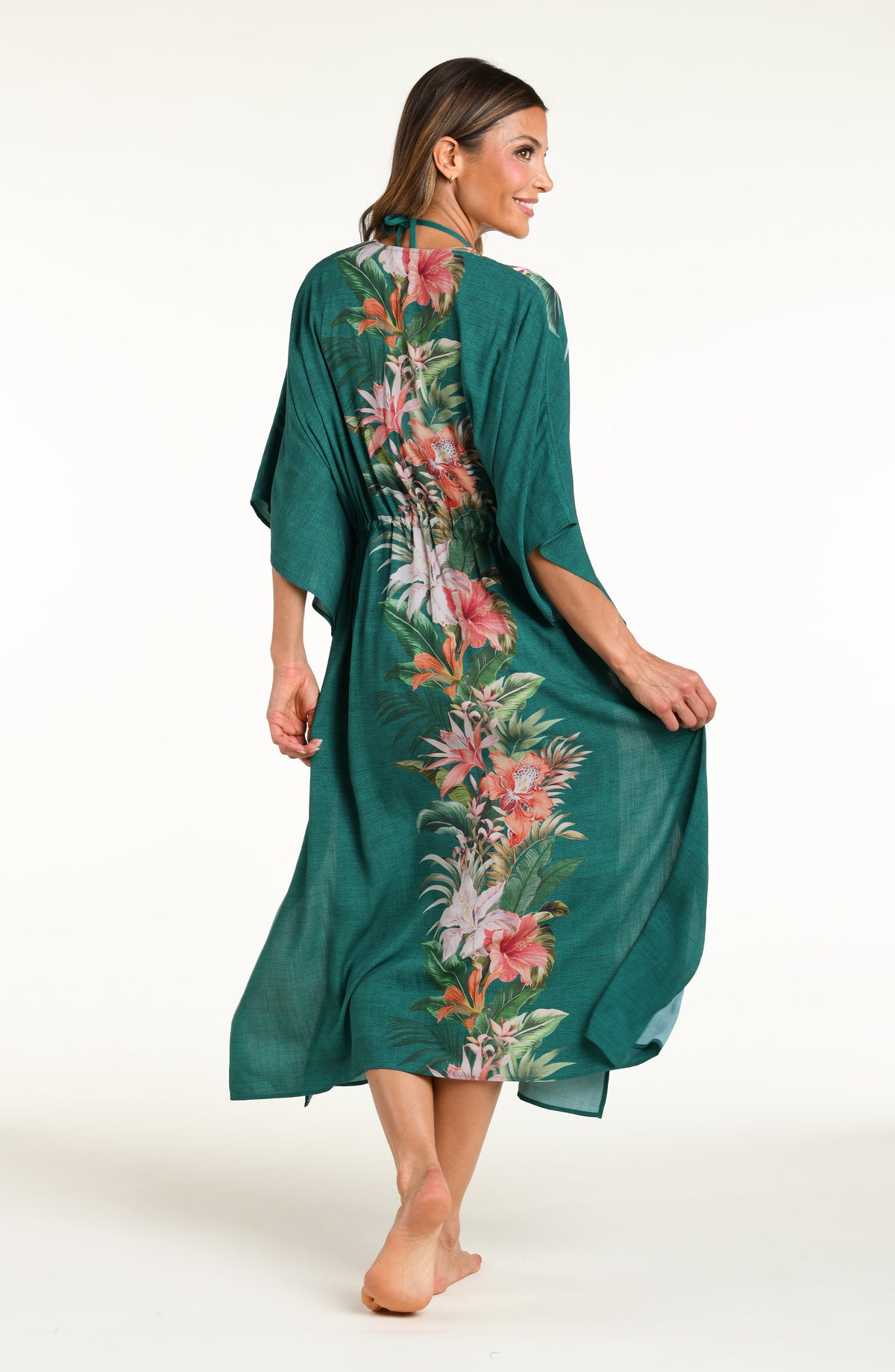 Woman wearing a jungle green multicolored long kimono against a white background. 