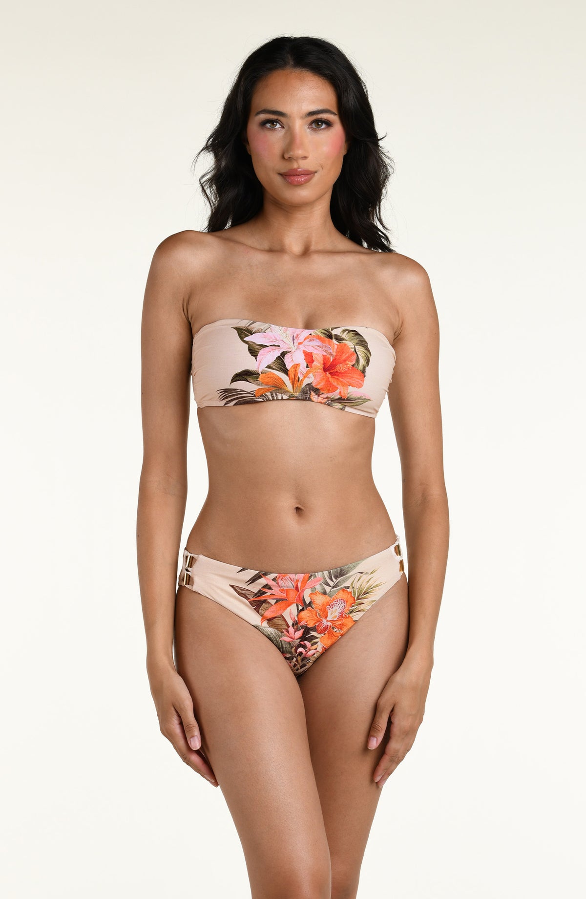 Woman wearing a multicolored white bandeau bikini top and matching bottom against a white background. 