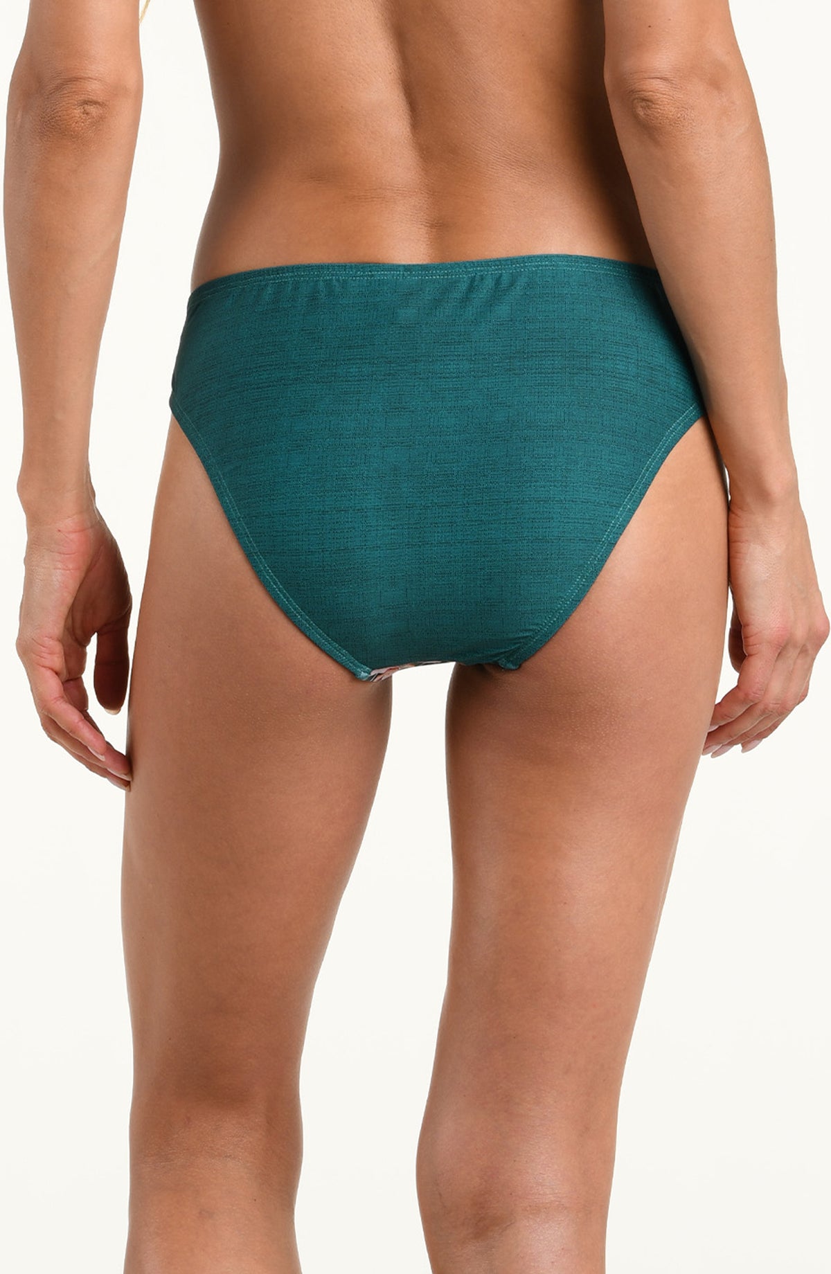 A model wearing a pair of bikini bottoms with a tropical floral and leaf print in teal green, pink, orange, and white, shown against a plain white background.