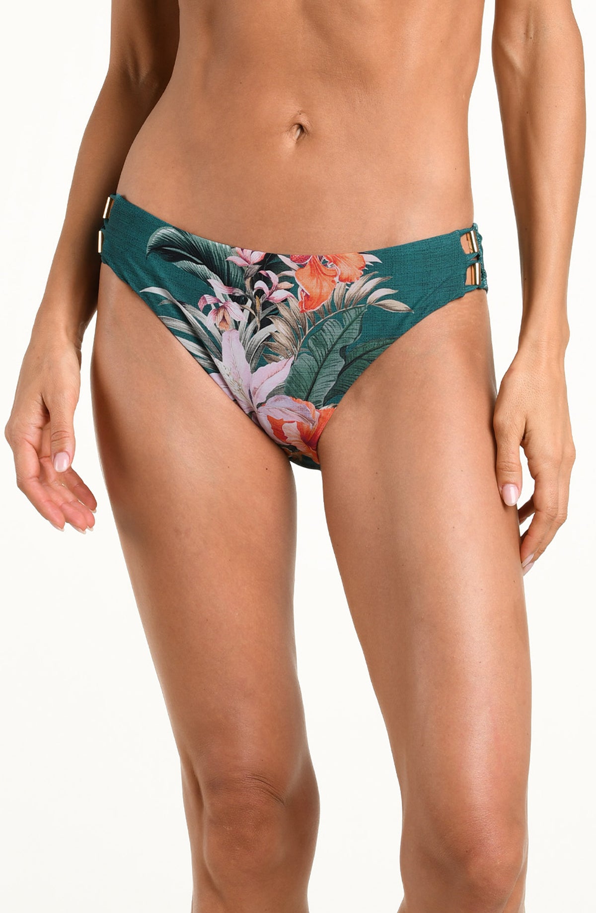 A model wearing a pair of bikini bottoms with a tropical floral and leaf print in teal green, pink, orange, and white, shown against a plain white background.