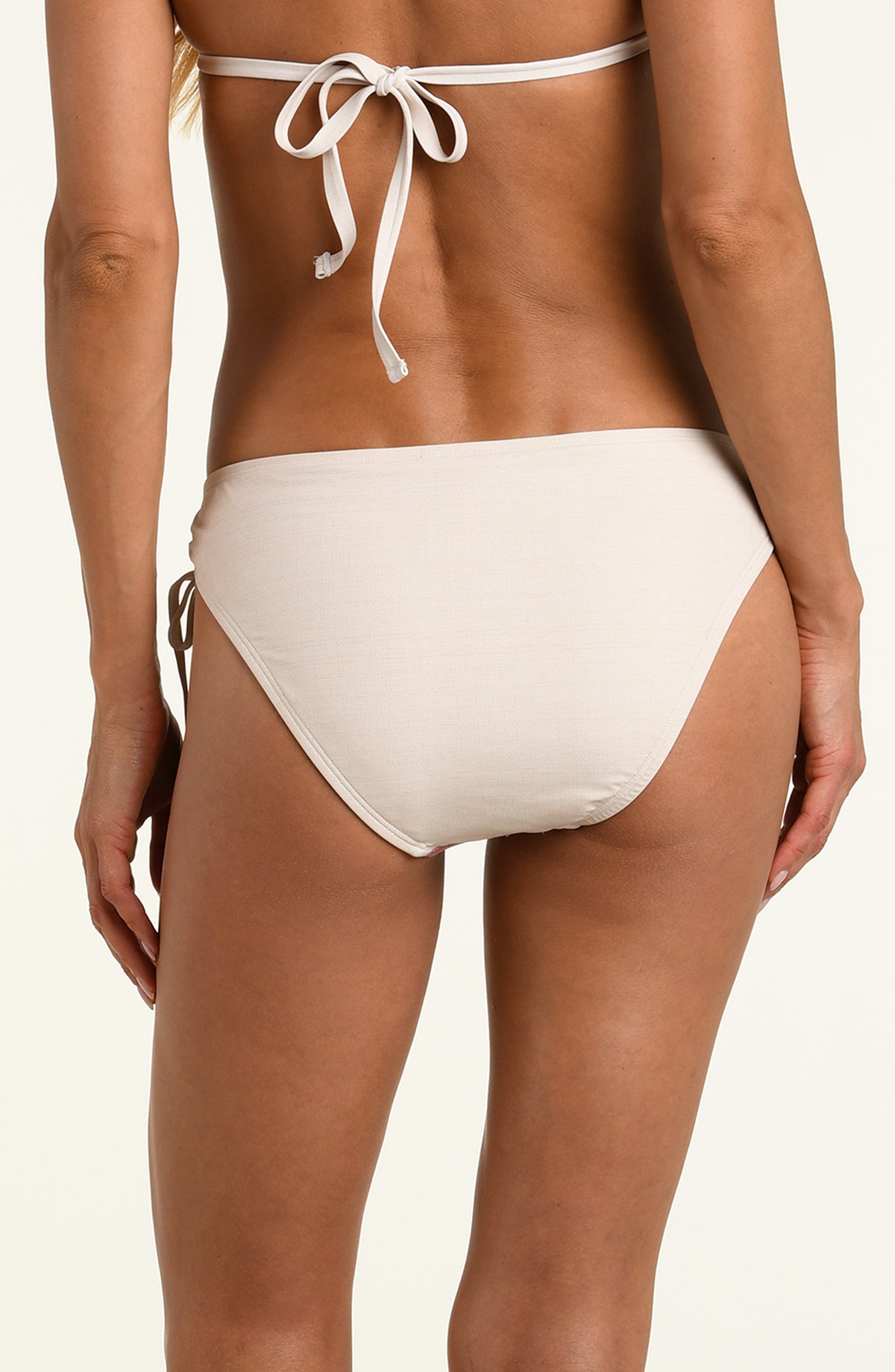 Woman wearing a multicolored white bikini bottom against a white background. 