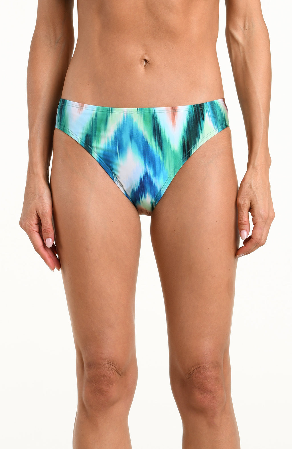 Woman wearing a multicolored teal bikini bottom against a white background. 