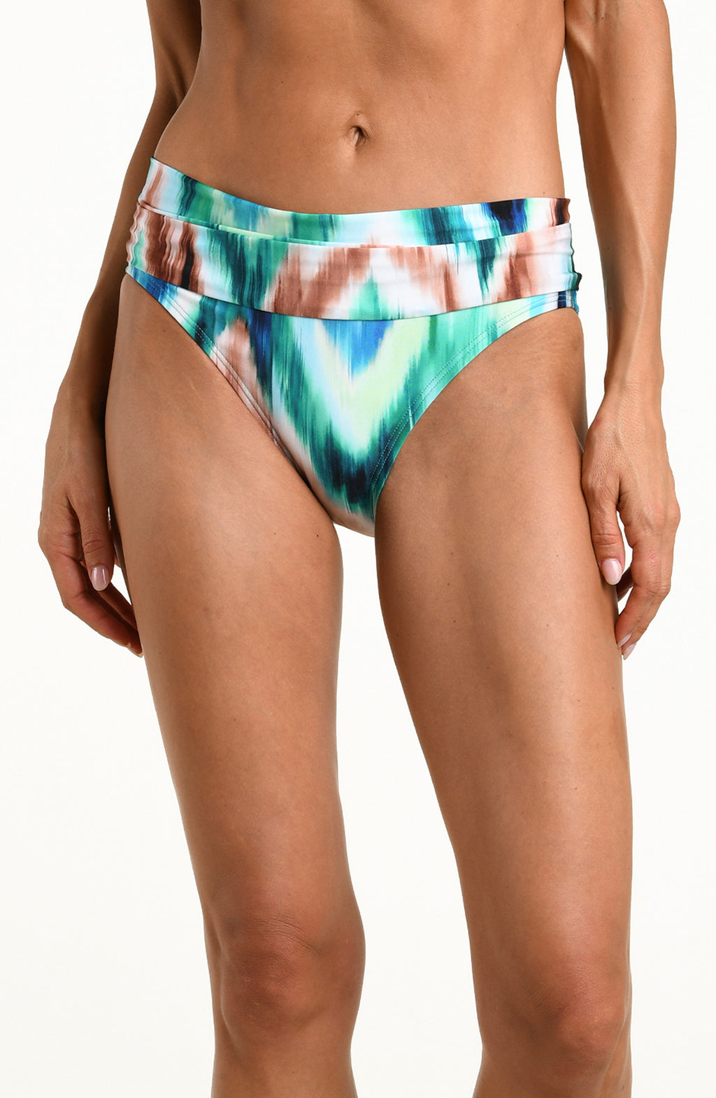 Woman wearing a multicolored teal bikini bottom against a white background. 