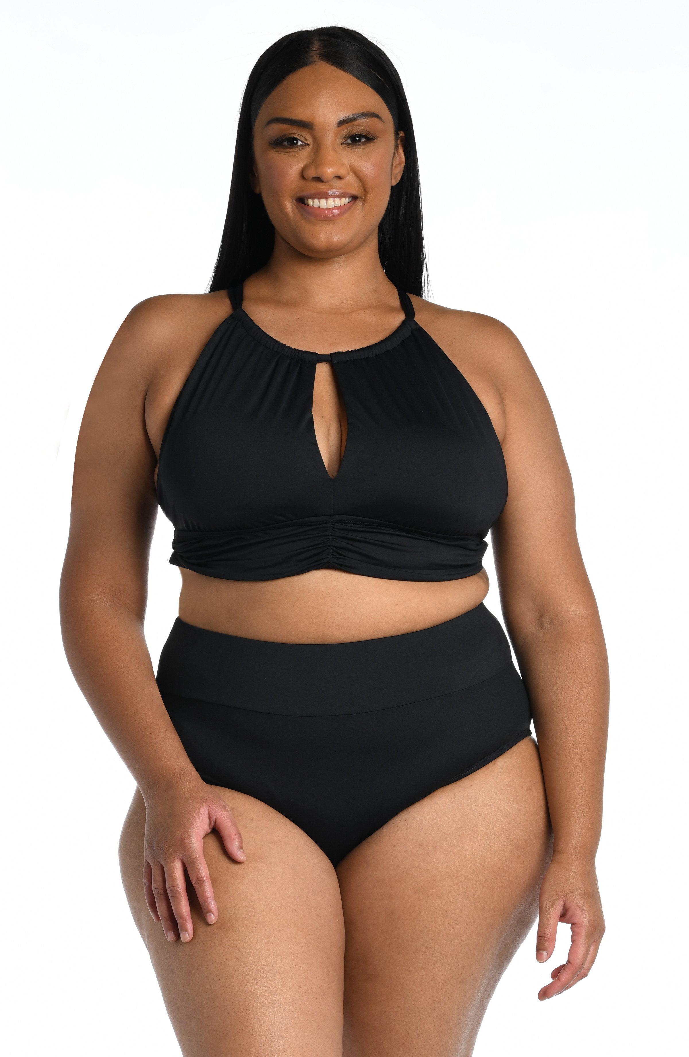 Woman wearing a black midkini top and matching bottom against a white background. 