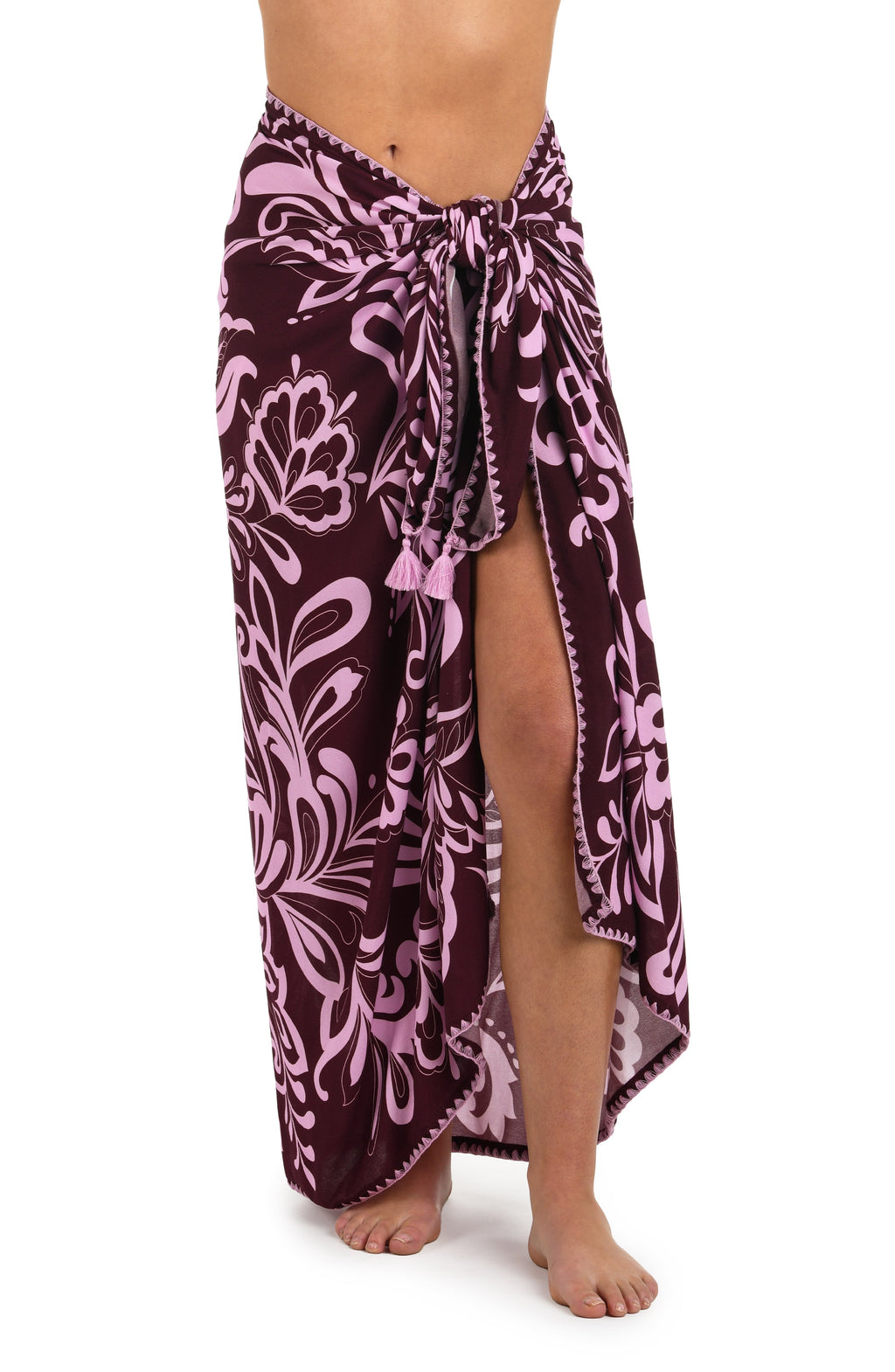 Front image of model wearing a dark cherry and pink tropical patterned pareo wrap cover up. 