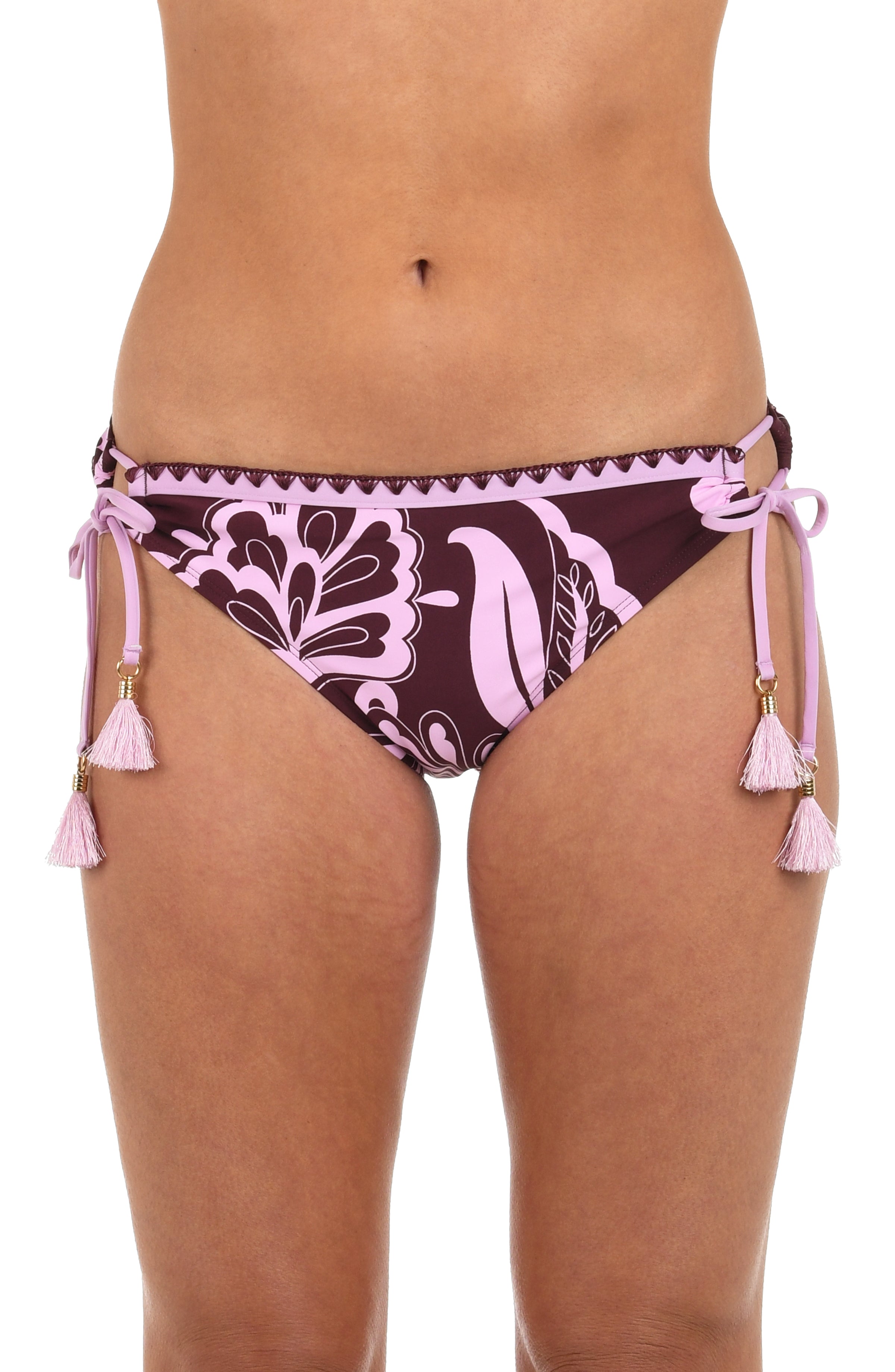 Front image of model wearing hipster bikini bottoms with side ties and tassels, in a bold pink and maroon floral print. 