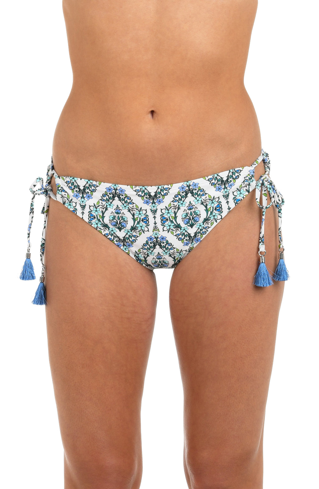 Front image of model wearing hipster bikini bottoms with a blue and green tile-inspired print, featuring side ties and tassels. 