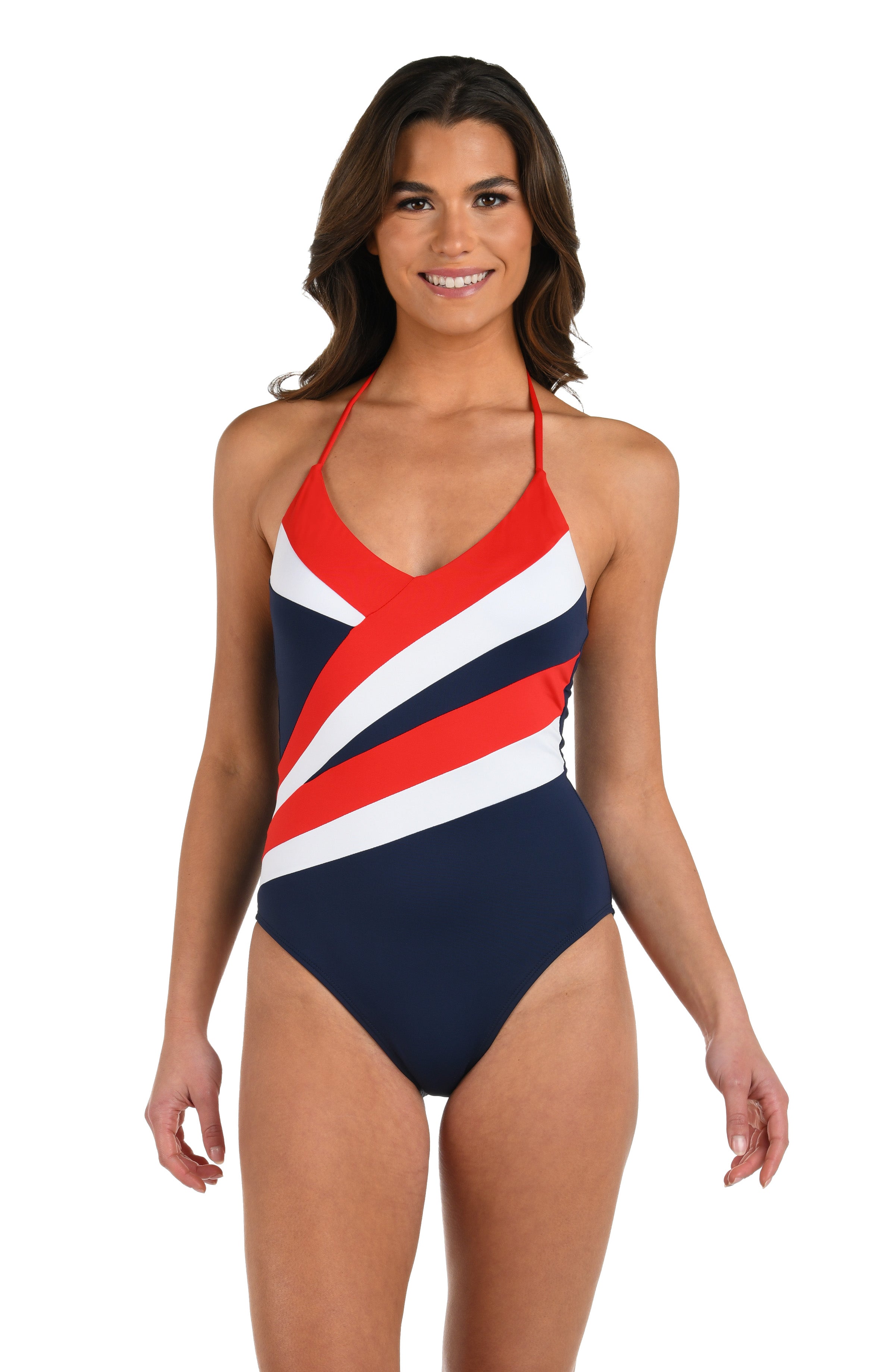 Woman wearing a one piece swimsuit featuring a plunging neckline and bold diagonal color-block stripes in red, white, and indigo blue.