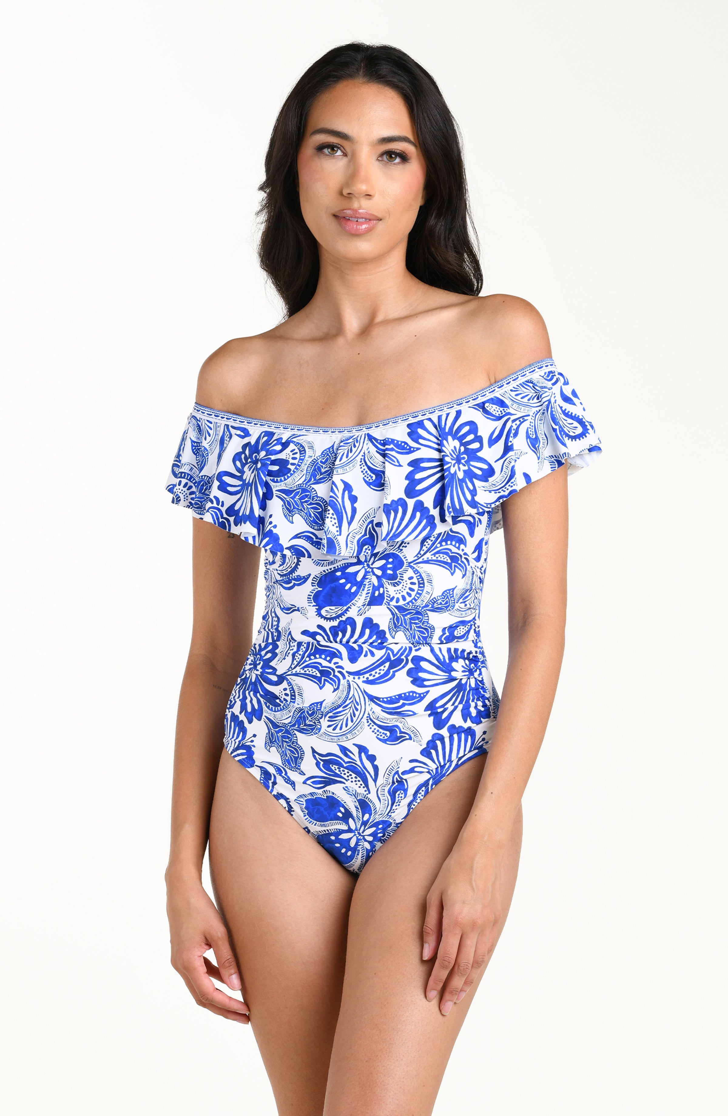 Woman wearing a blue floral off-shoulder swimsuit on a white background