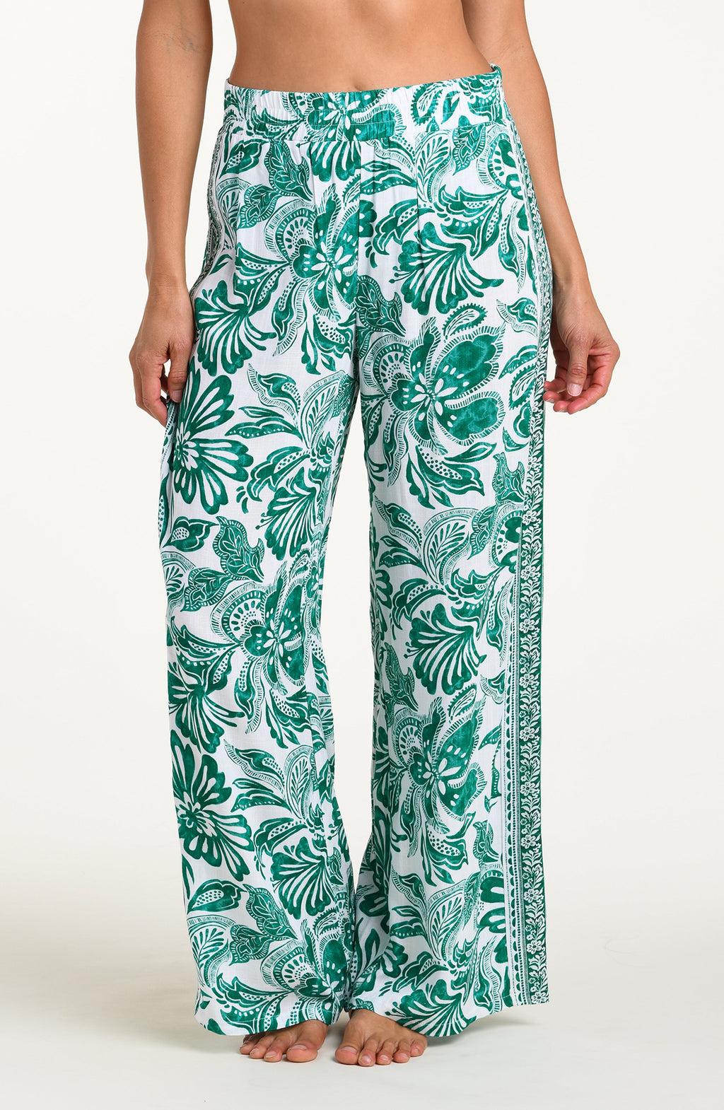 Green and white floral-patterned pants on a white background