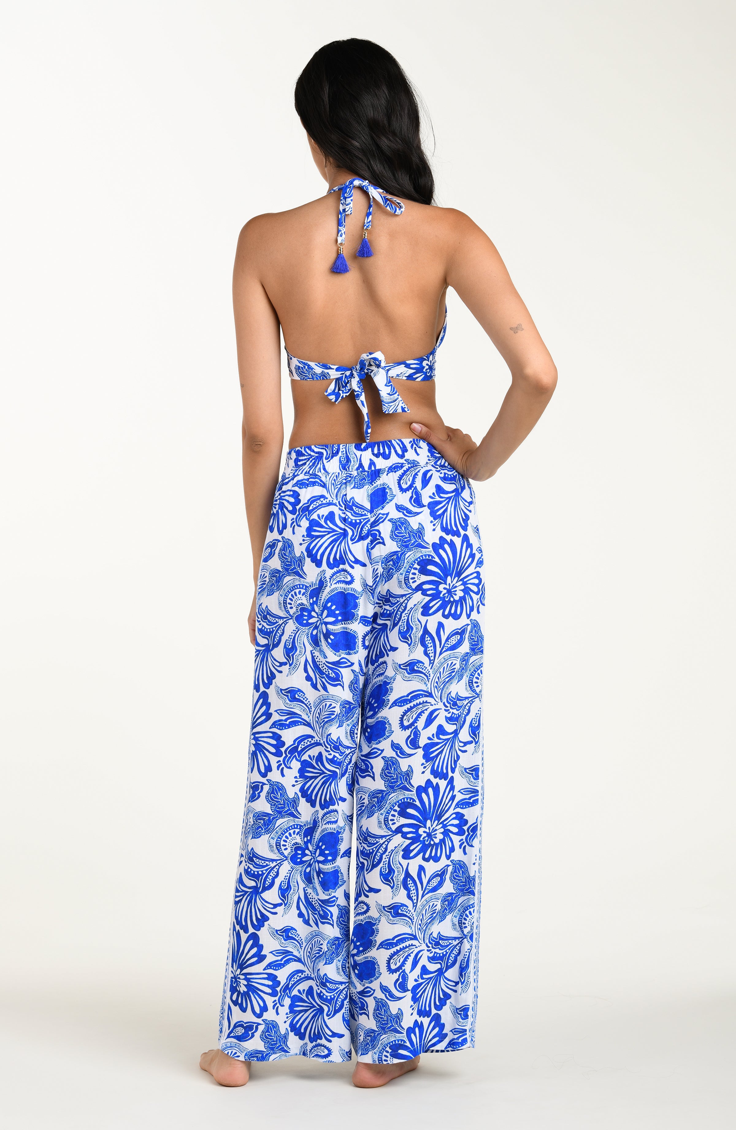Woman wearing a blue floral two-piece outfit on a white background