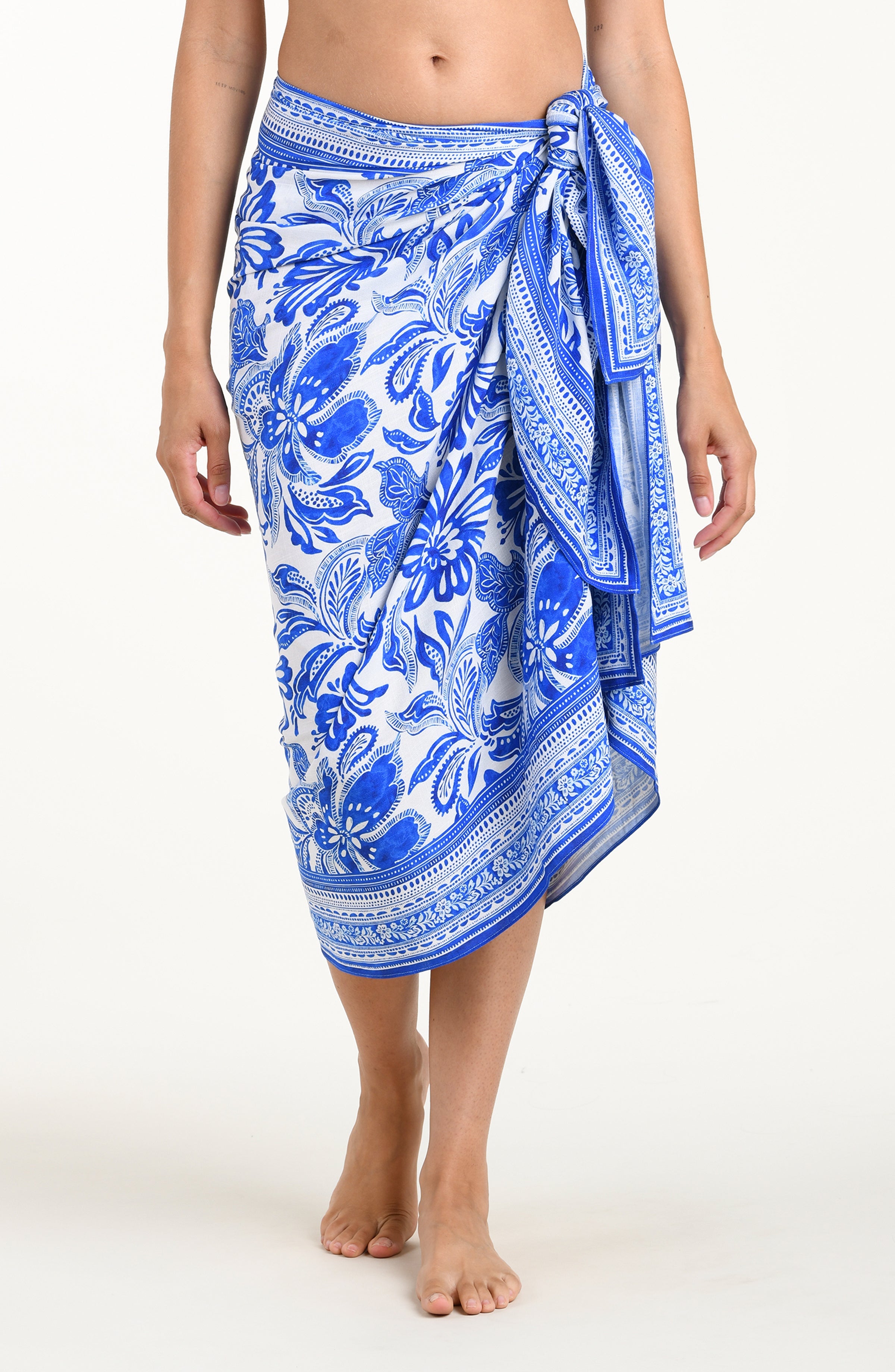 Person wearing a blue and white patterned sarong on a white background