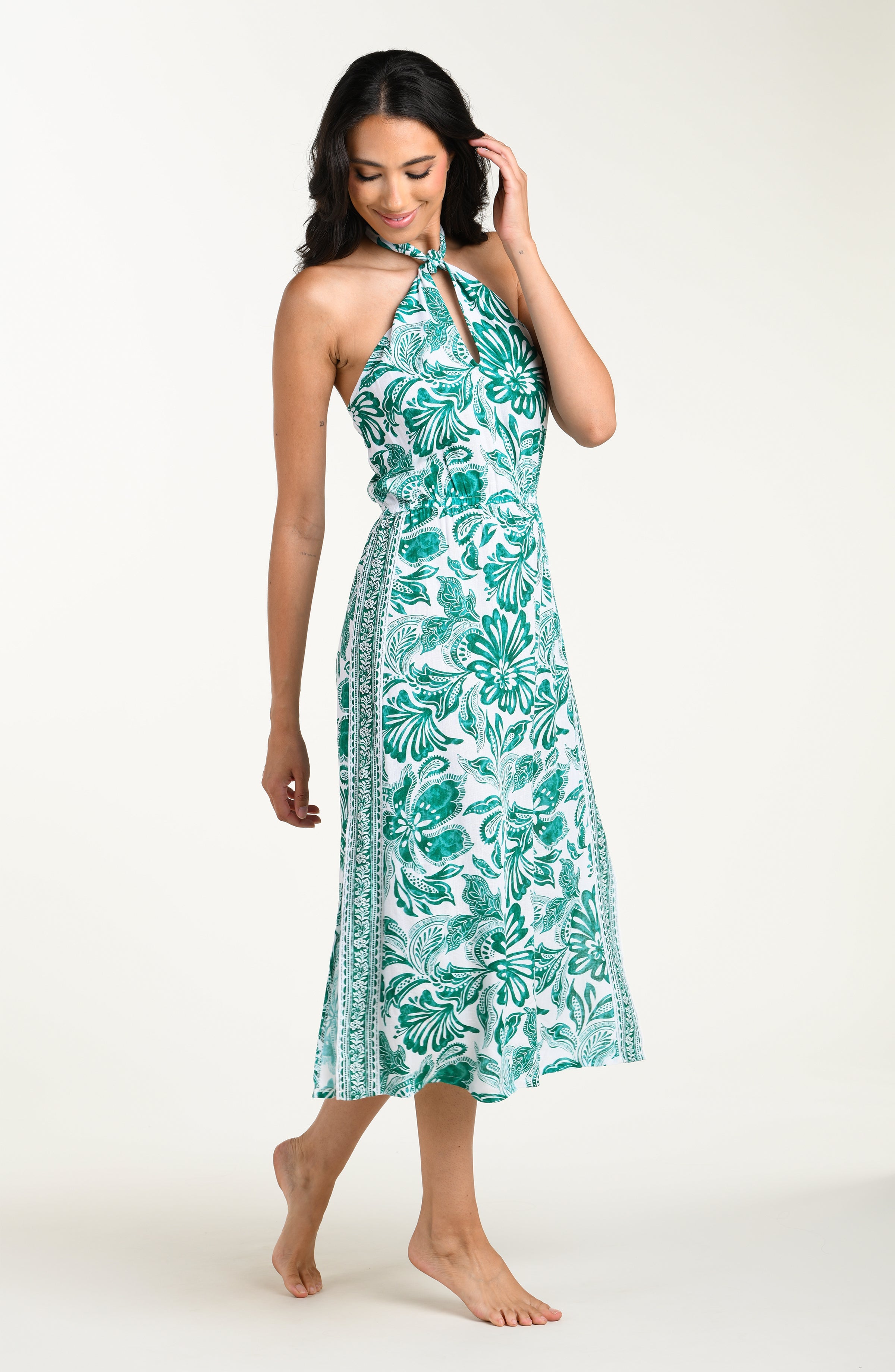 Woman wearing a green floral dress on a white background