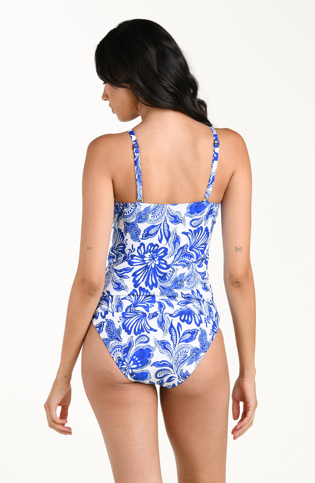 Woman wearing a blue floral tankini top and matching bottoms on a white background