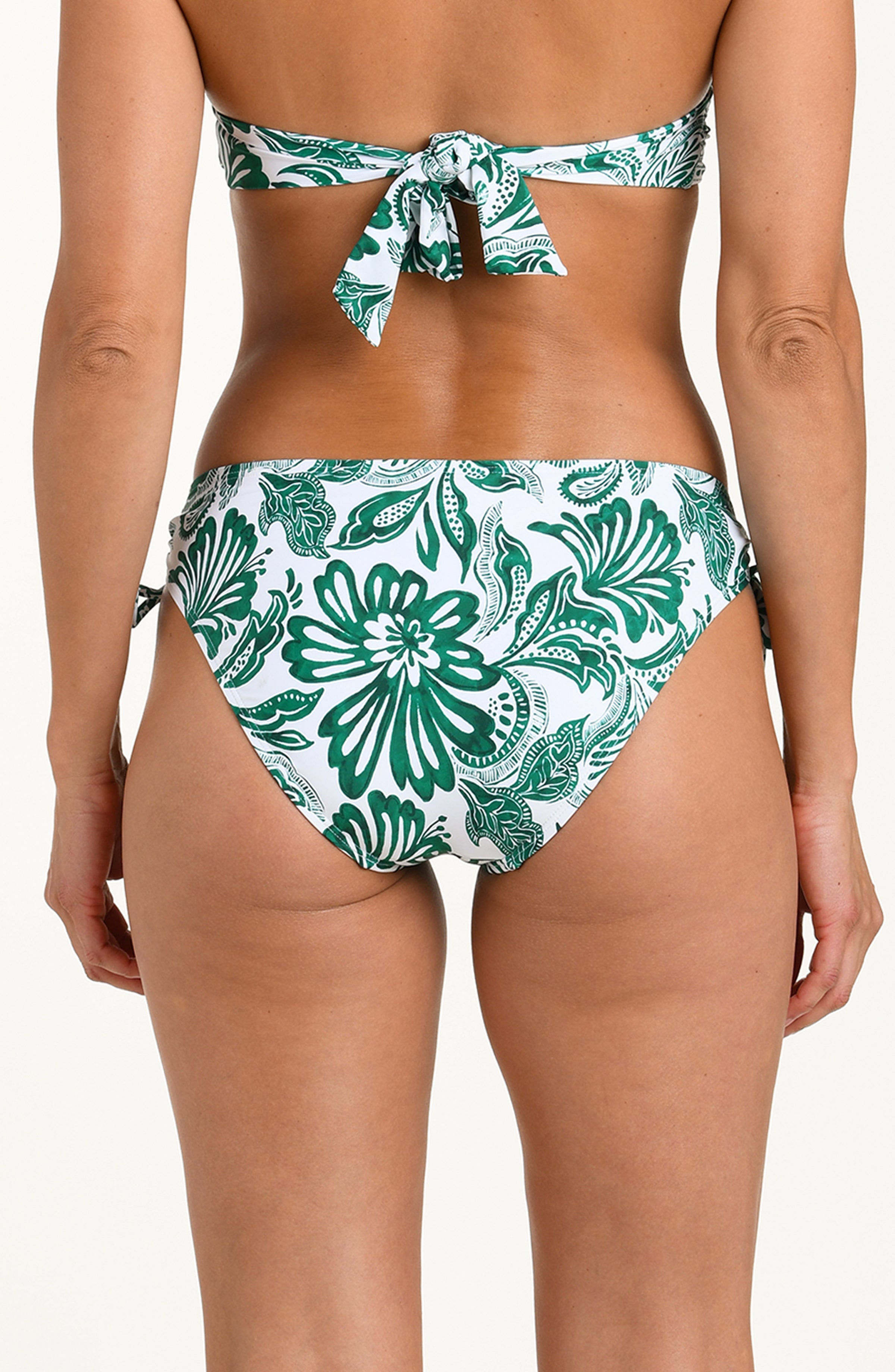 Green and white floral bikini on a plain background