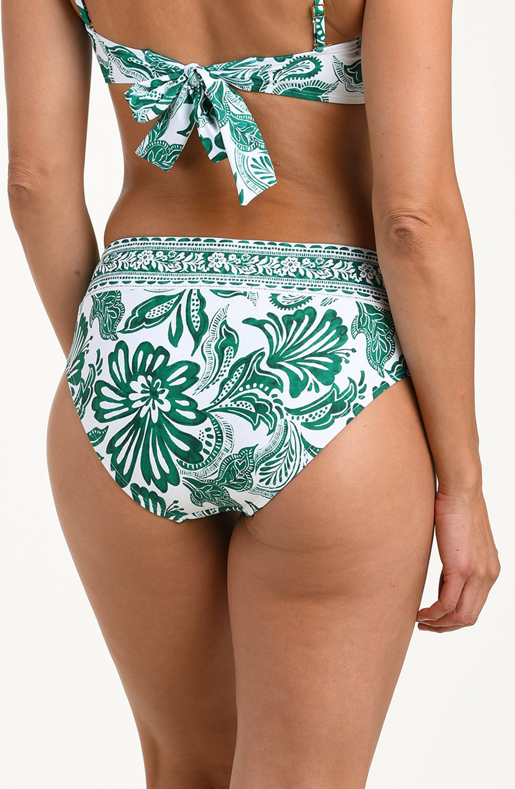 Green and white patterned bikini on a plain background
