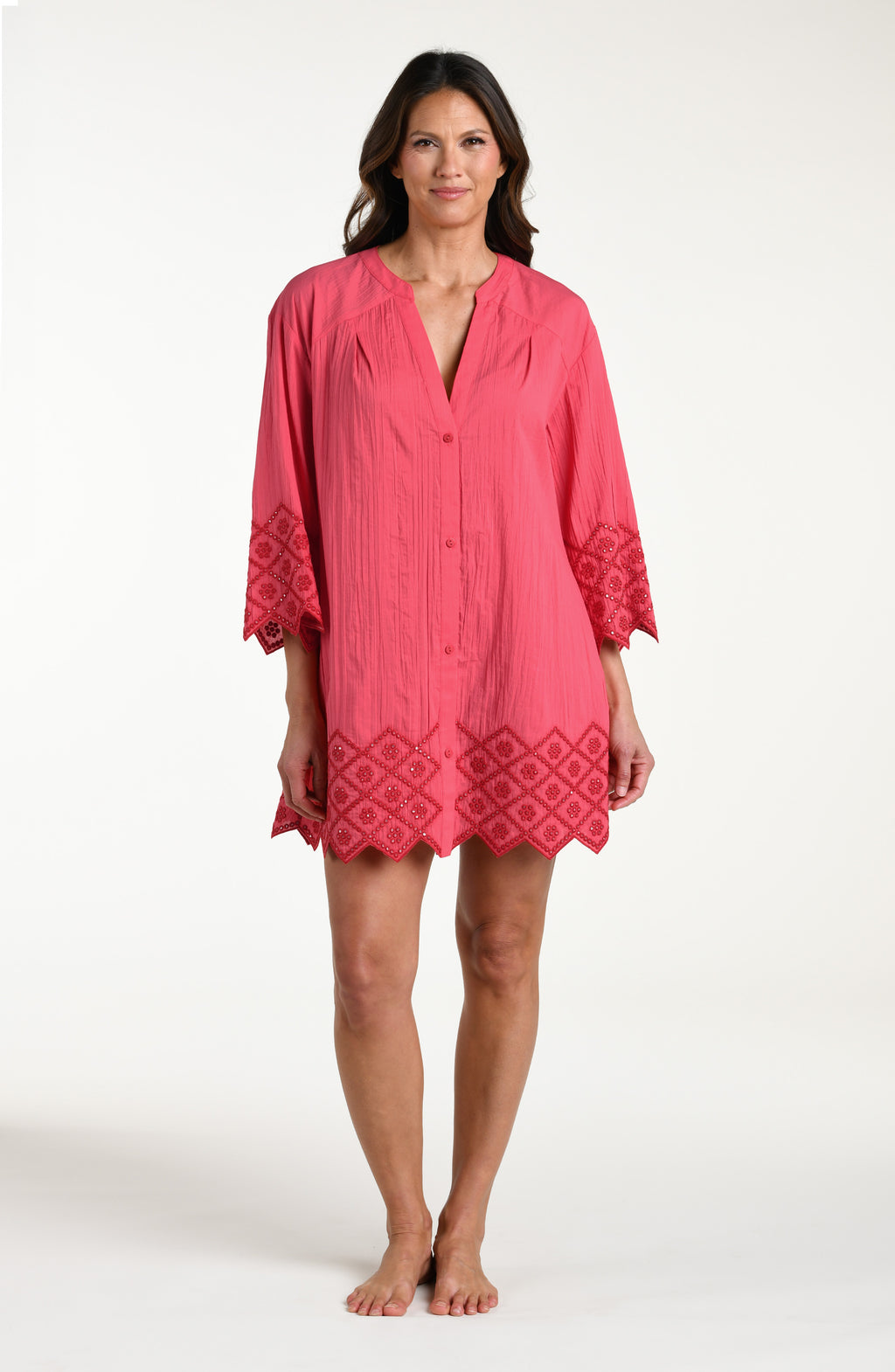 Woman wearing a guava colored V-neck tunic against a white background. 