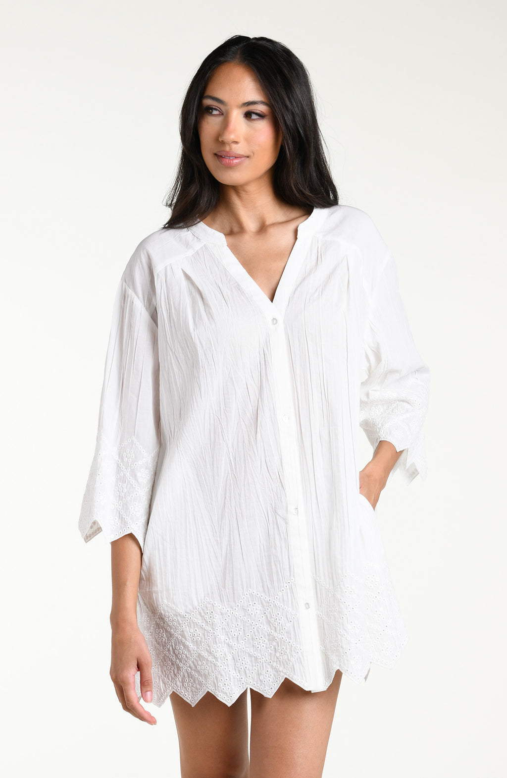 Woman wearing a white V-neck tunic against a white background