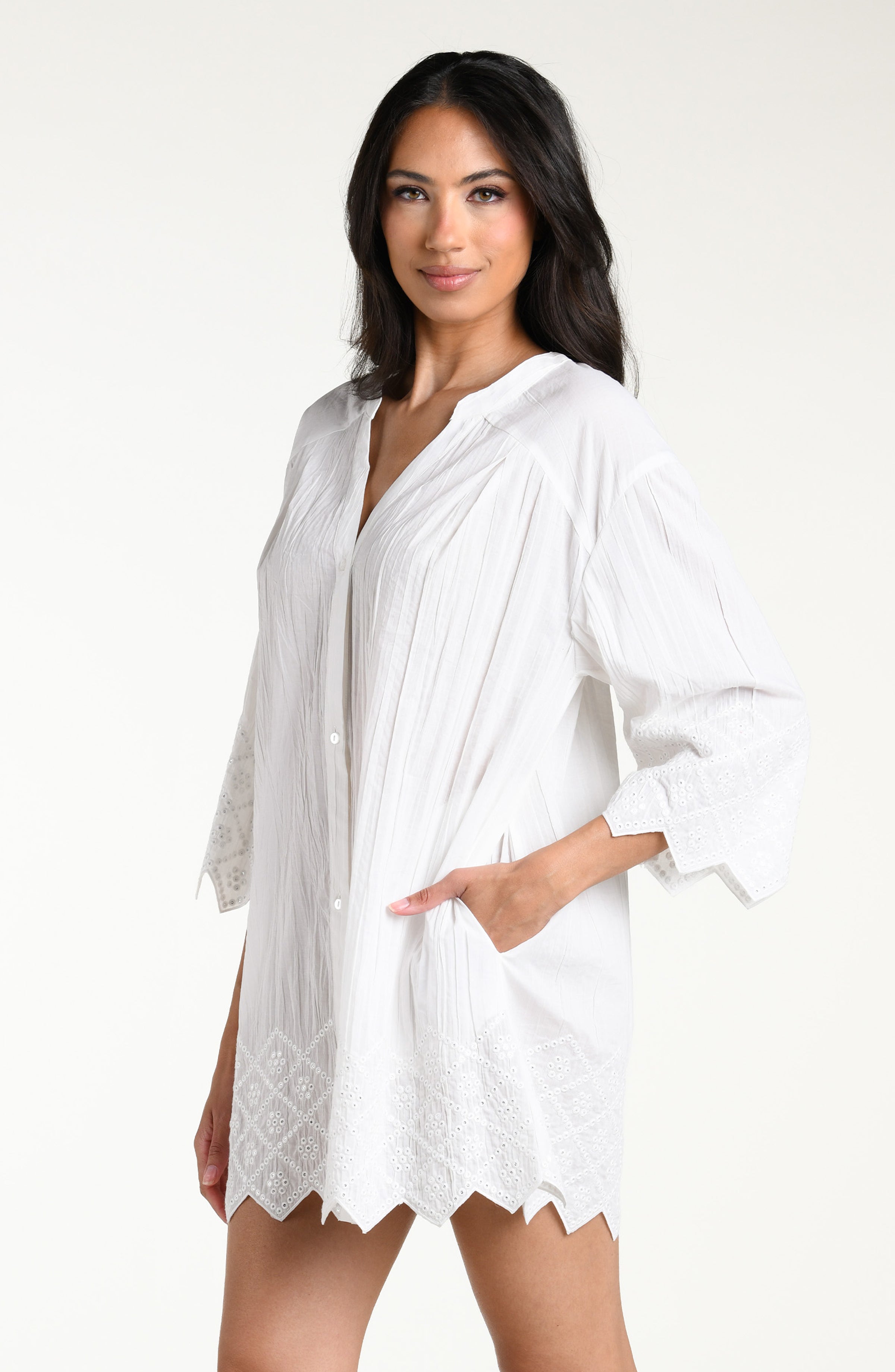 Woman wearing a white V-neck tunic against a white background