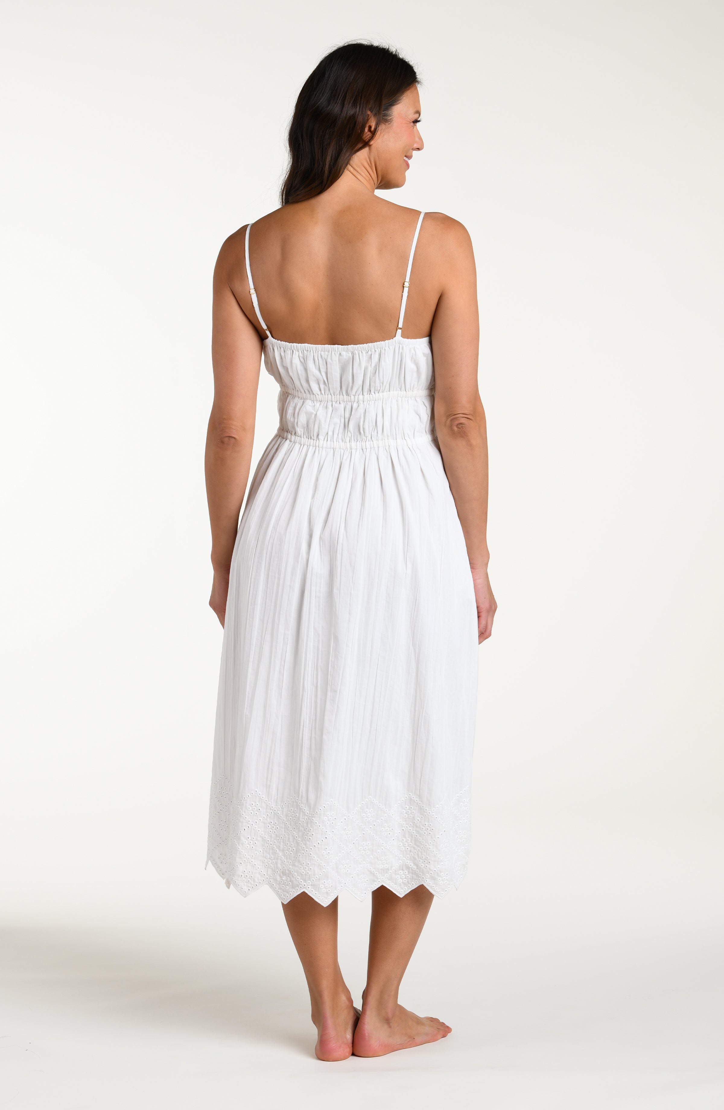 Woman wearing a white midi cover up dress against a white background