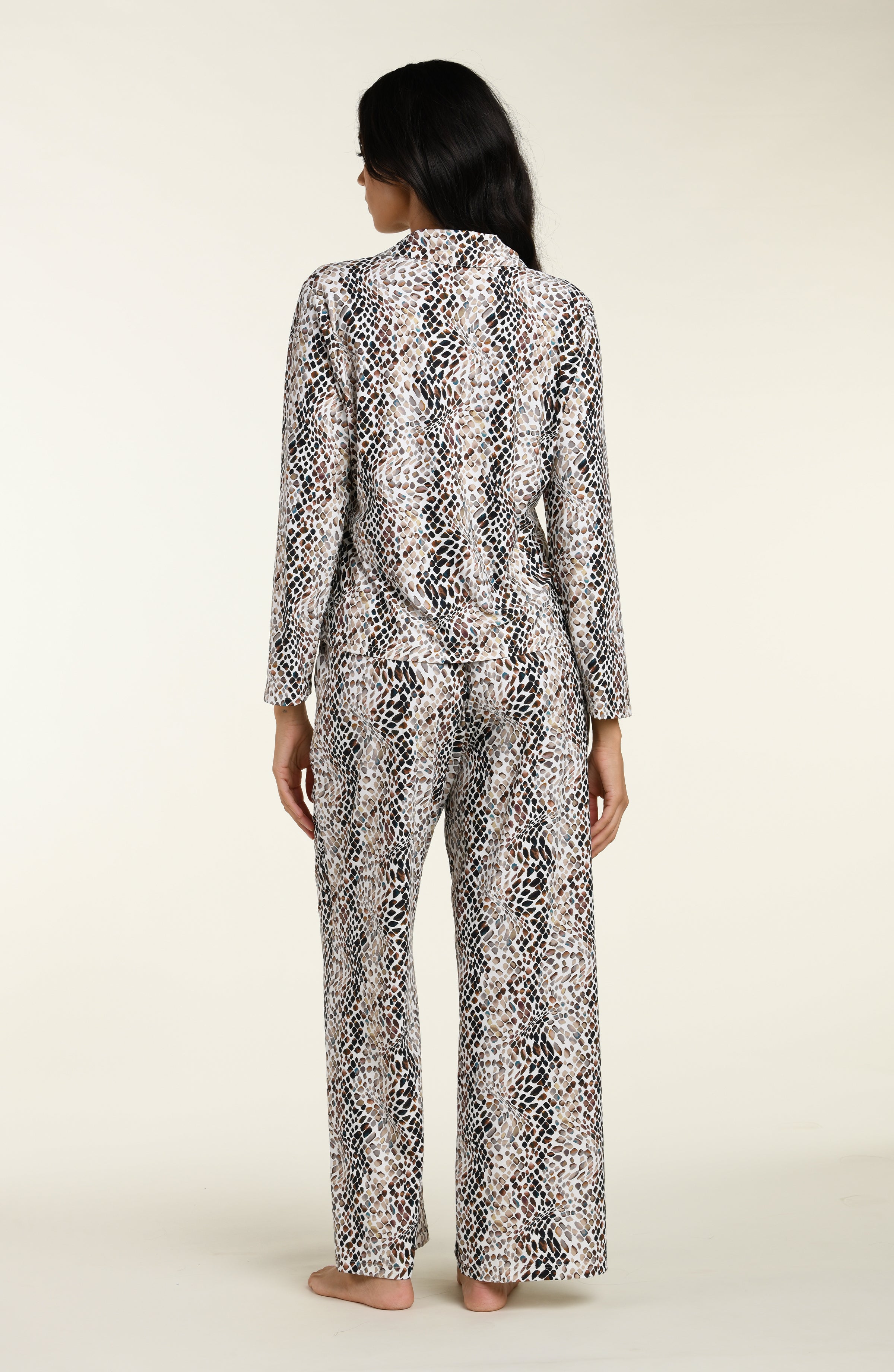 Woman wearing a snake print long sleeves and pants pajama set against a white background