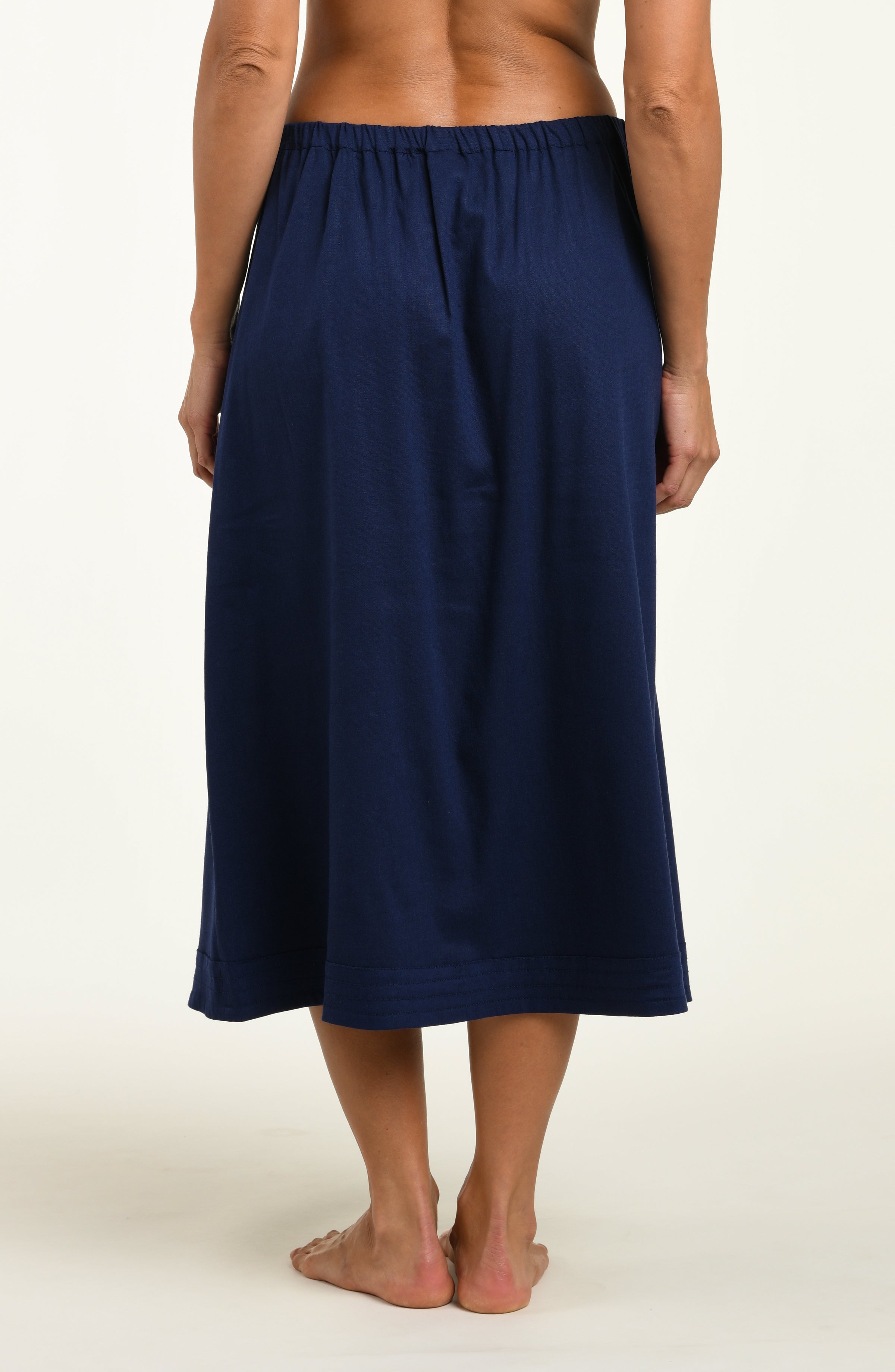 Woman wearing a navy cover up skirt against a white background.