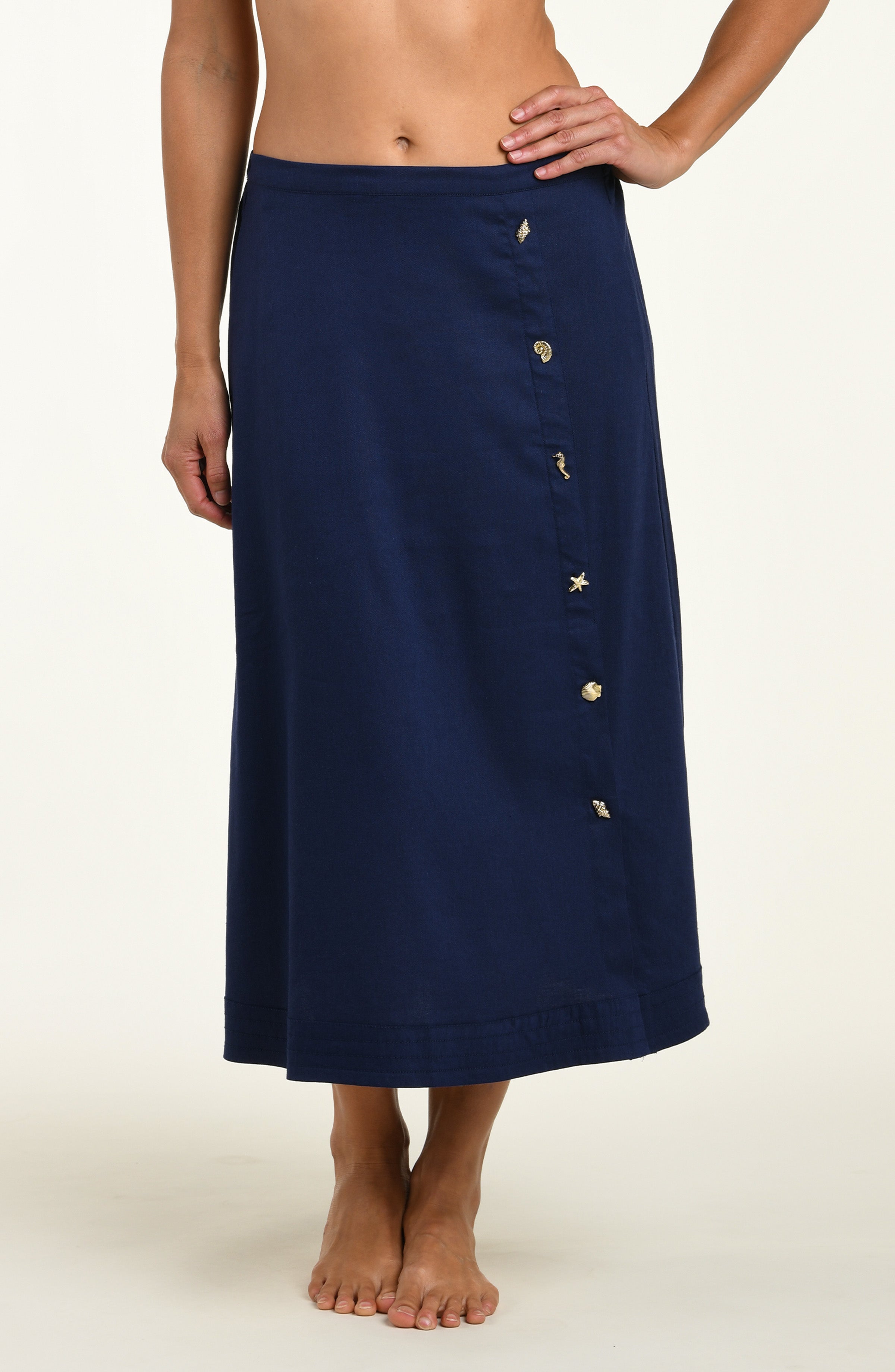 Woman wearing a navy cover up skirt against a white background.