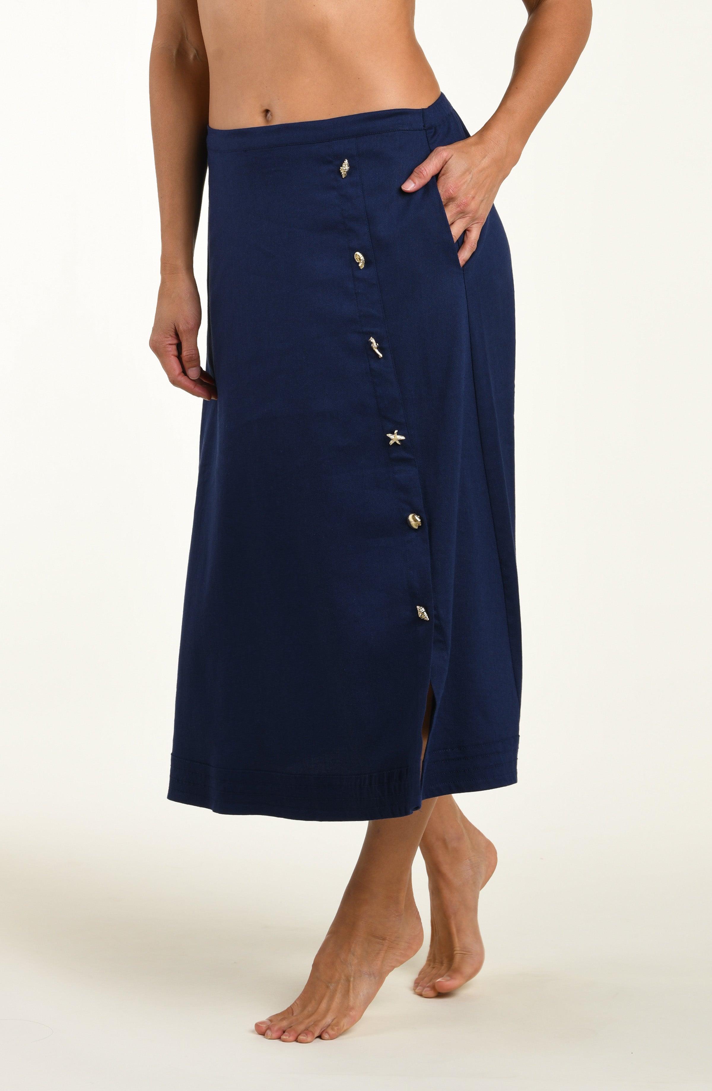Woman wearing a navy cover up skirt against a white background.