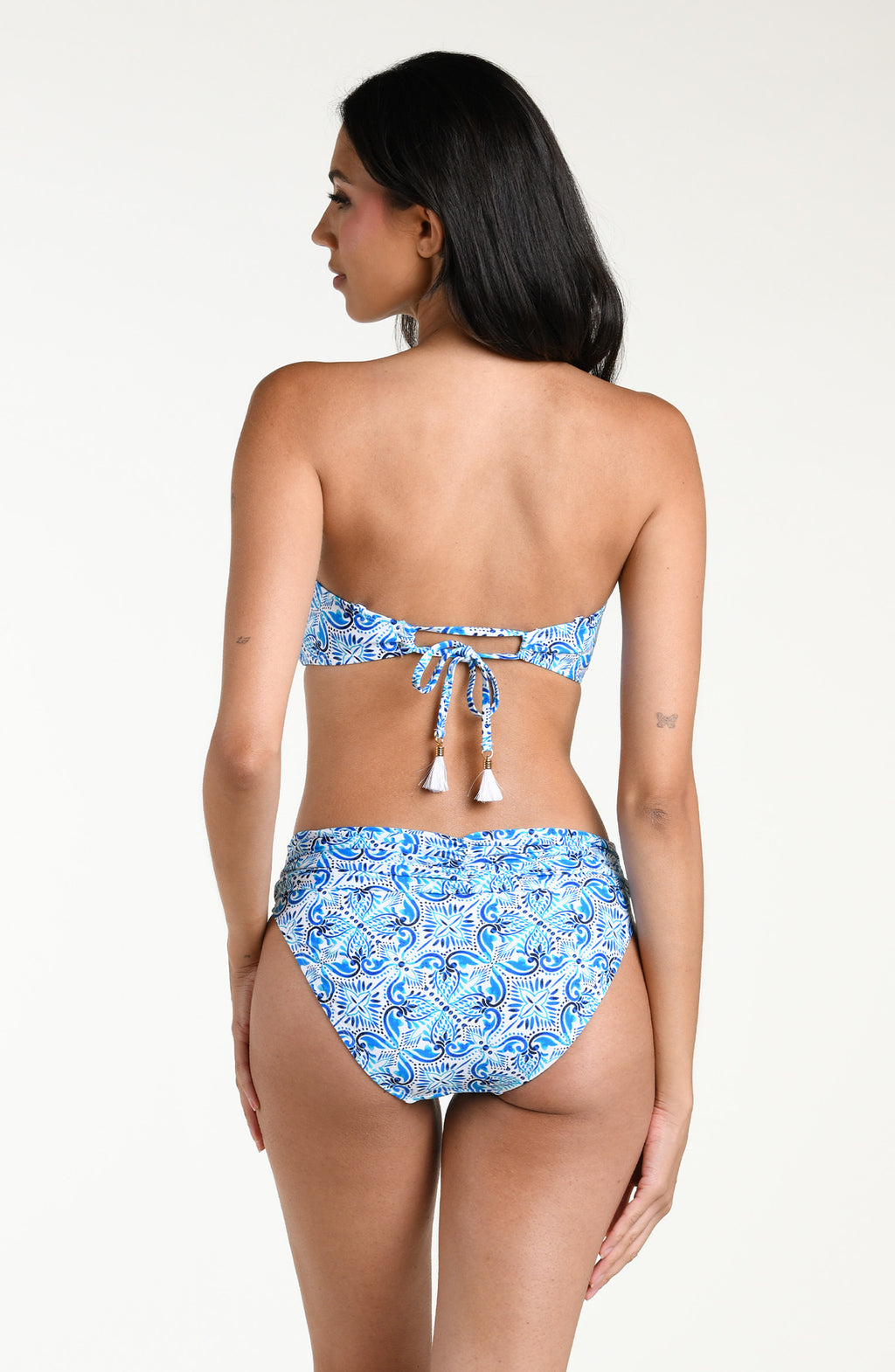Woman wearing a blue patterned bandeau bikini top and matching bottom against a white background.