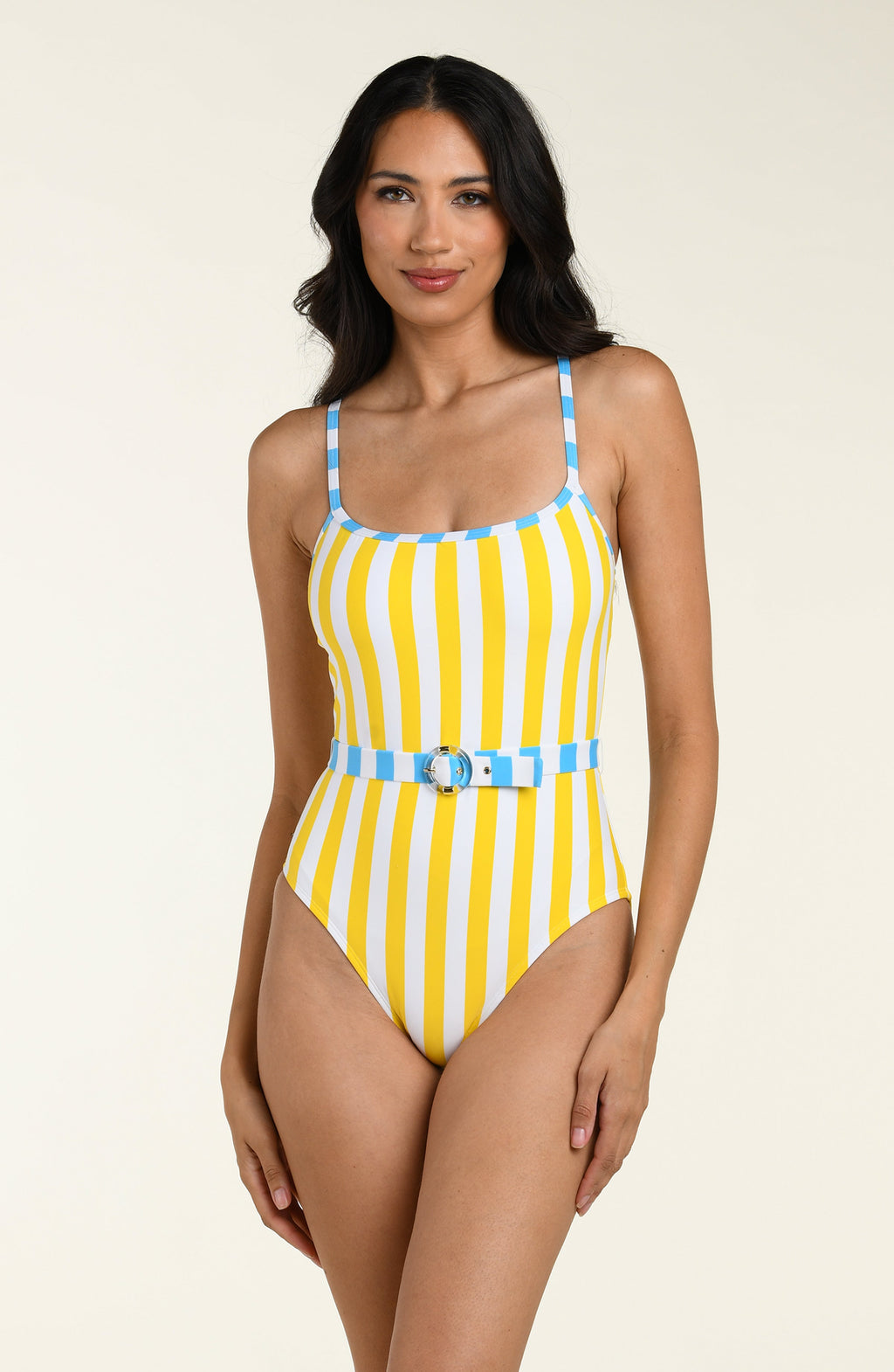 Woman wearing a yellow and blue striped one piece swimsuit on a beige background