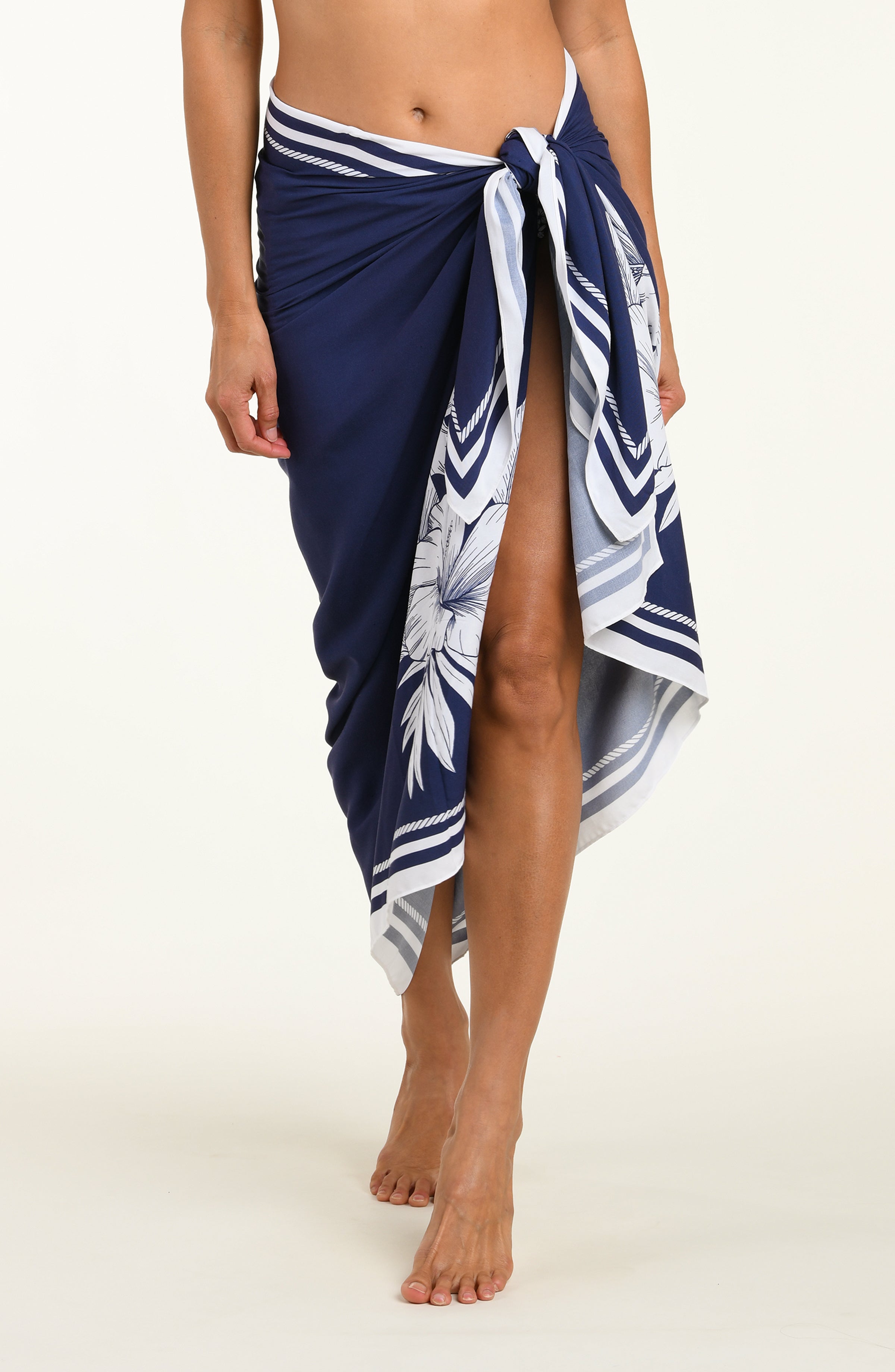 Person wearing a navy blue sarong with white floral patterns on a white background