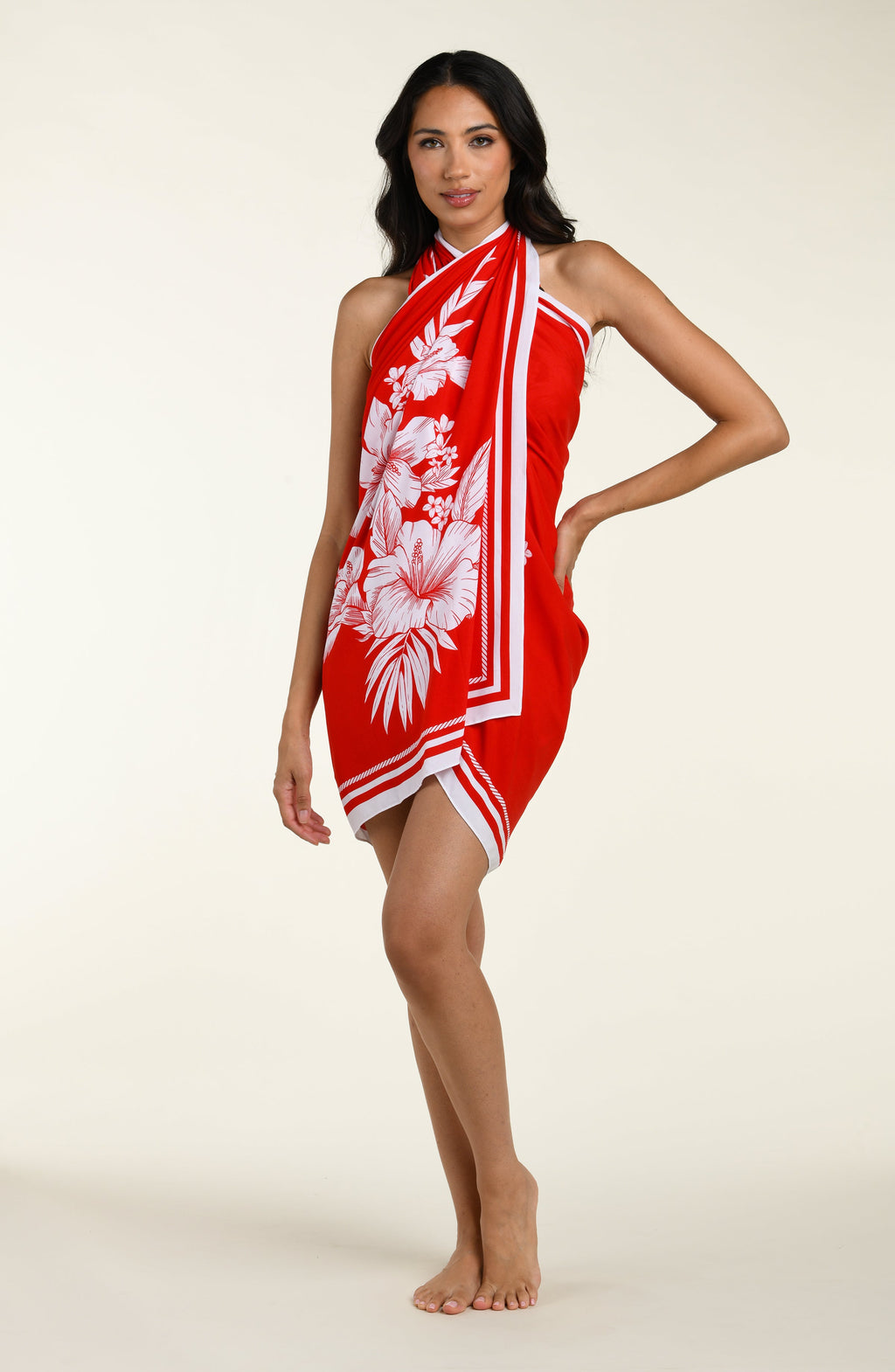 Woman wearing a red and white patterned sarong on a plain background