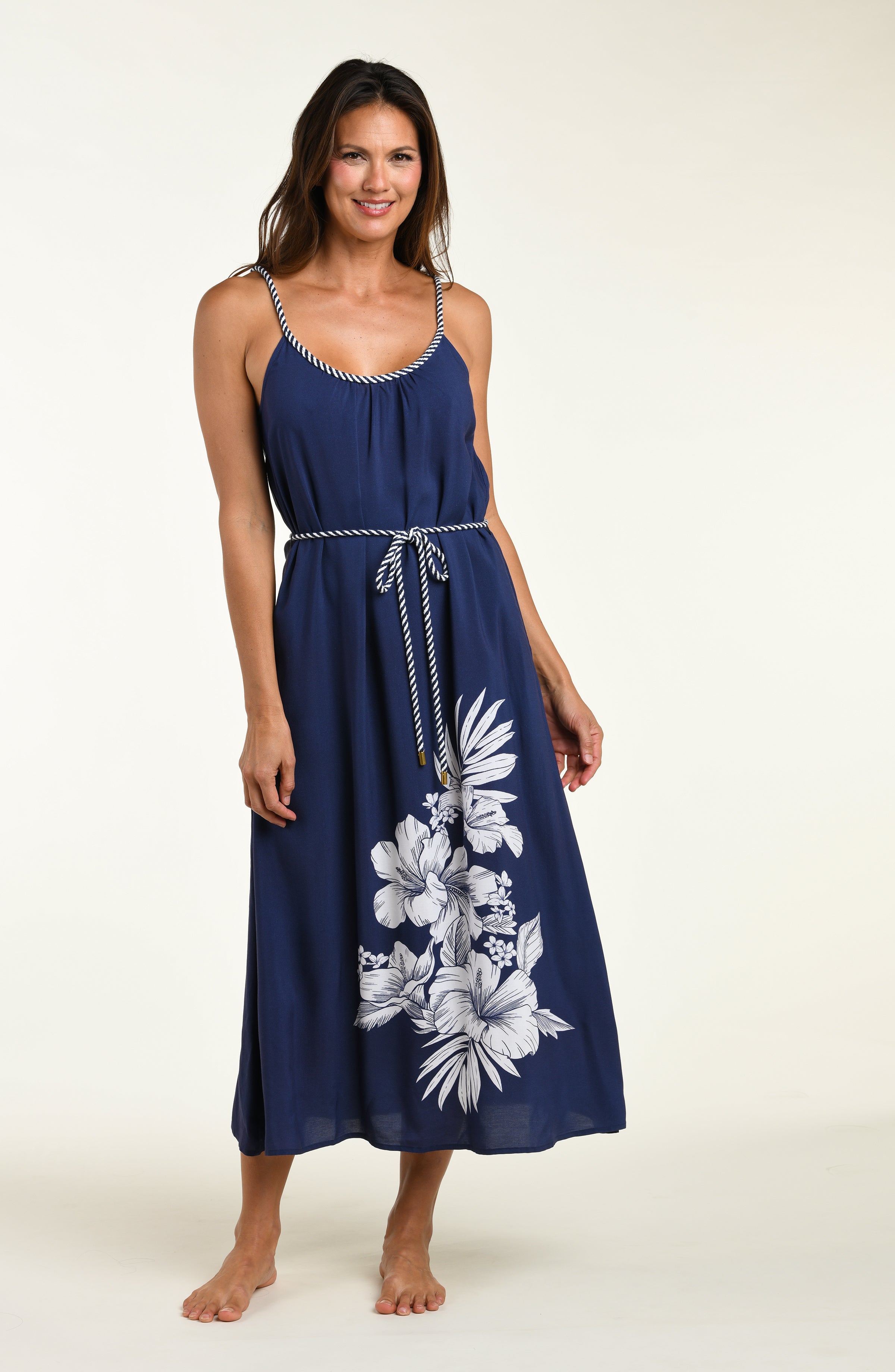 Woman wearing a navy blue cover up dress with floral patterns on a white background