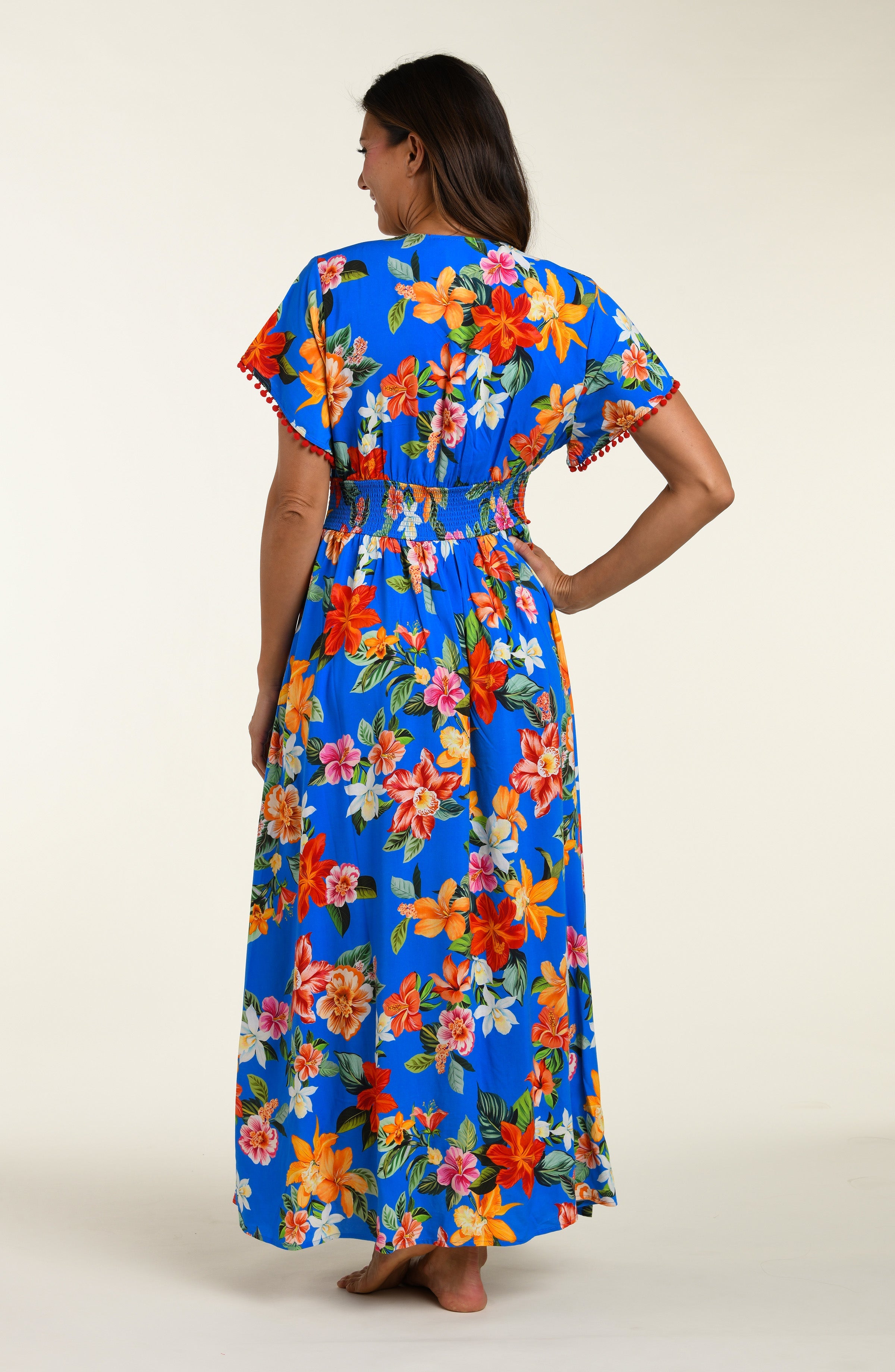 Woman wearing a colorful floral cover up dress on a white background