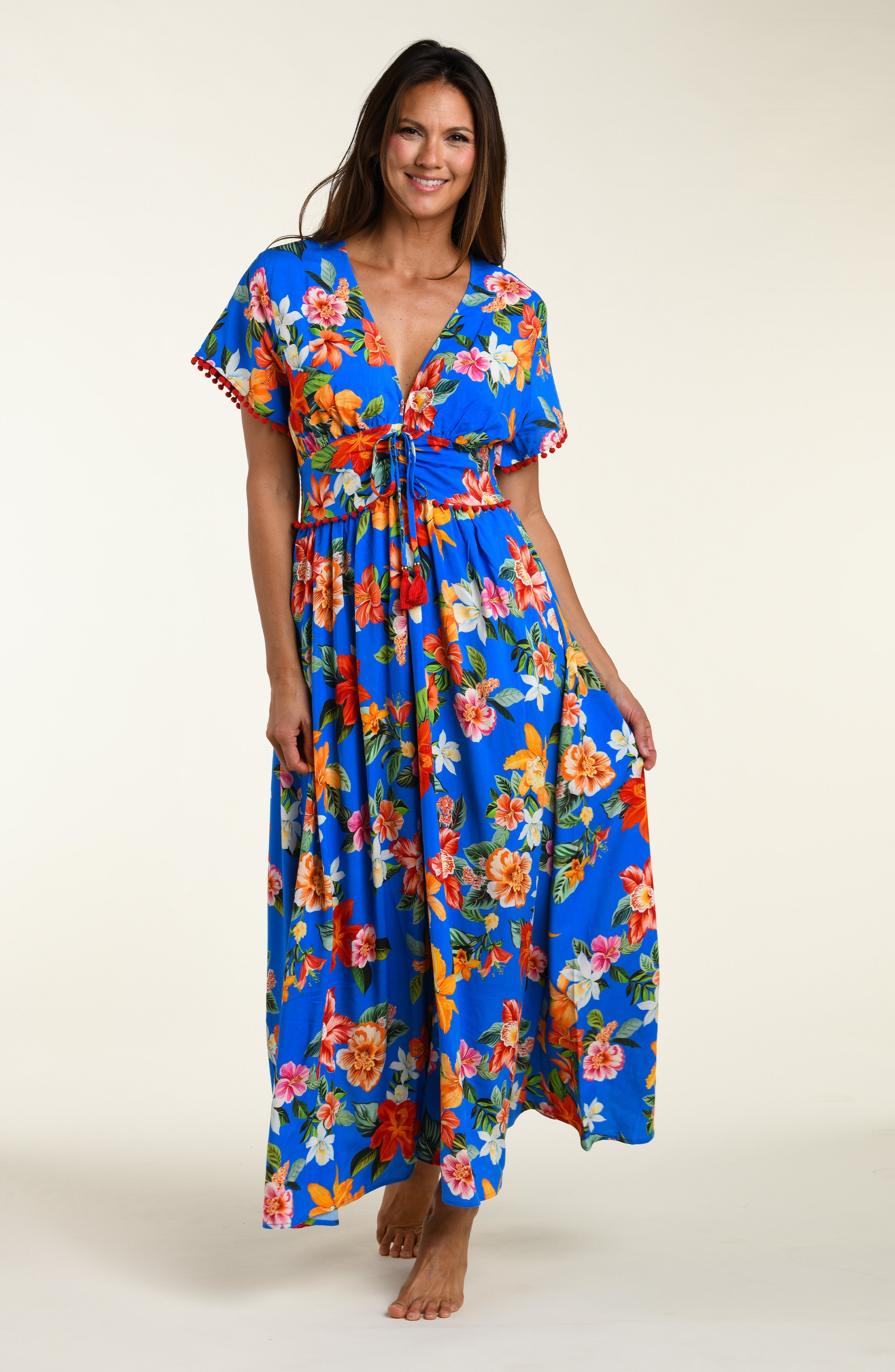 Woman wearing a colorful floral cover up dress on a white background
