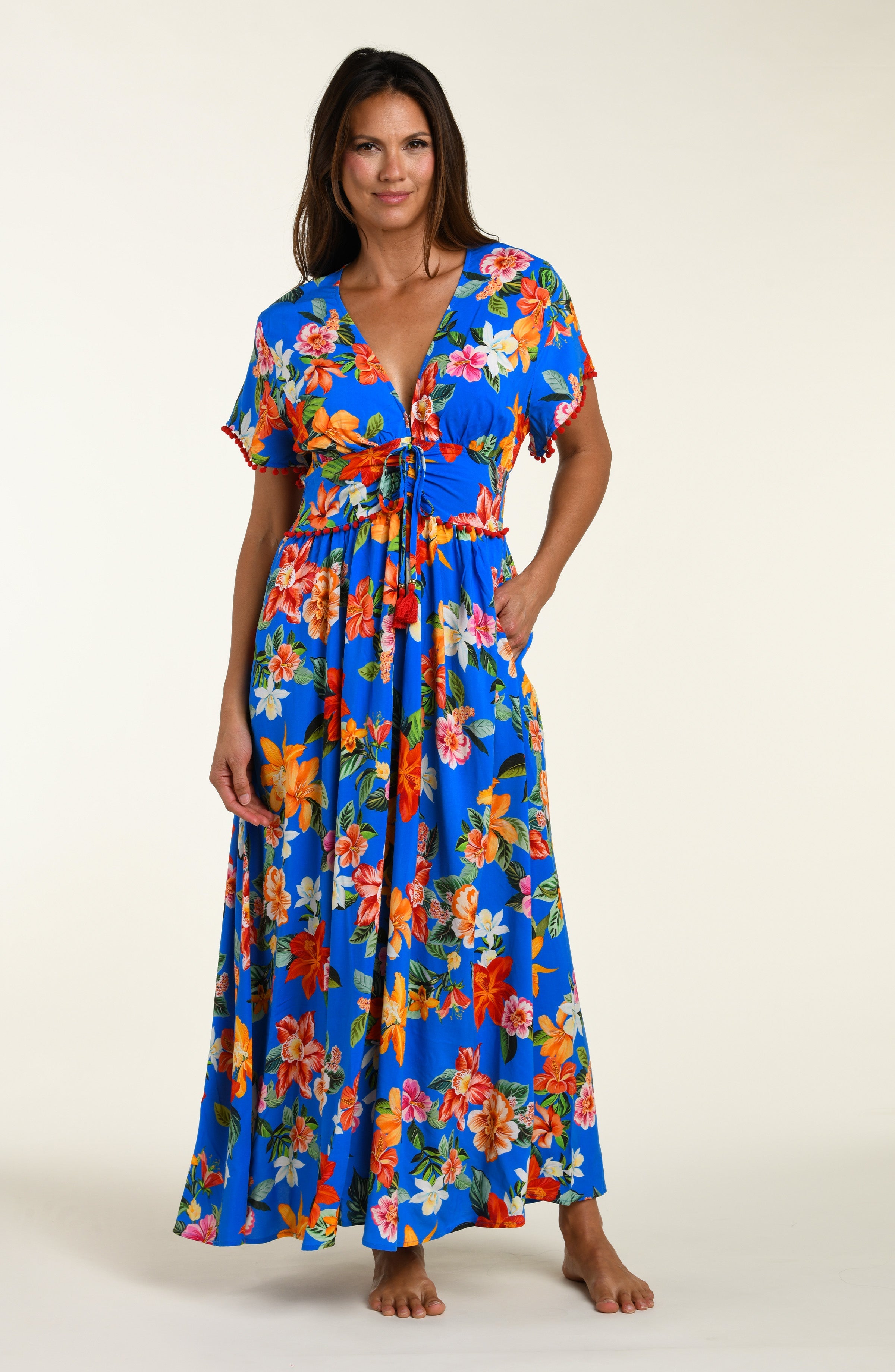 Woman wearing a colorful floral cover up dress on a white background