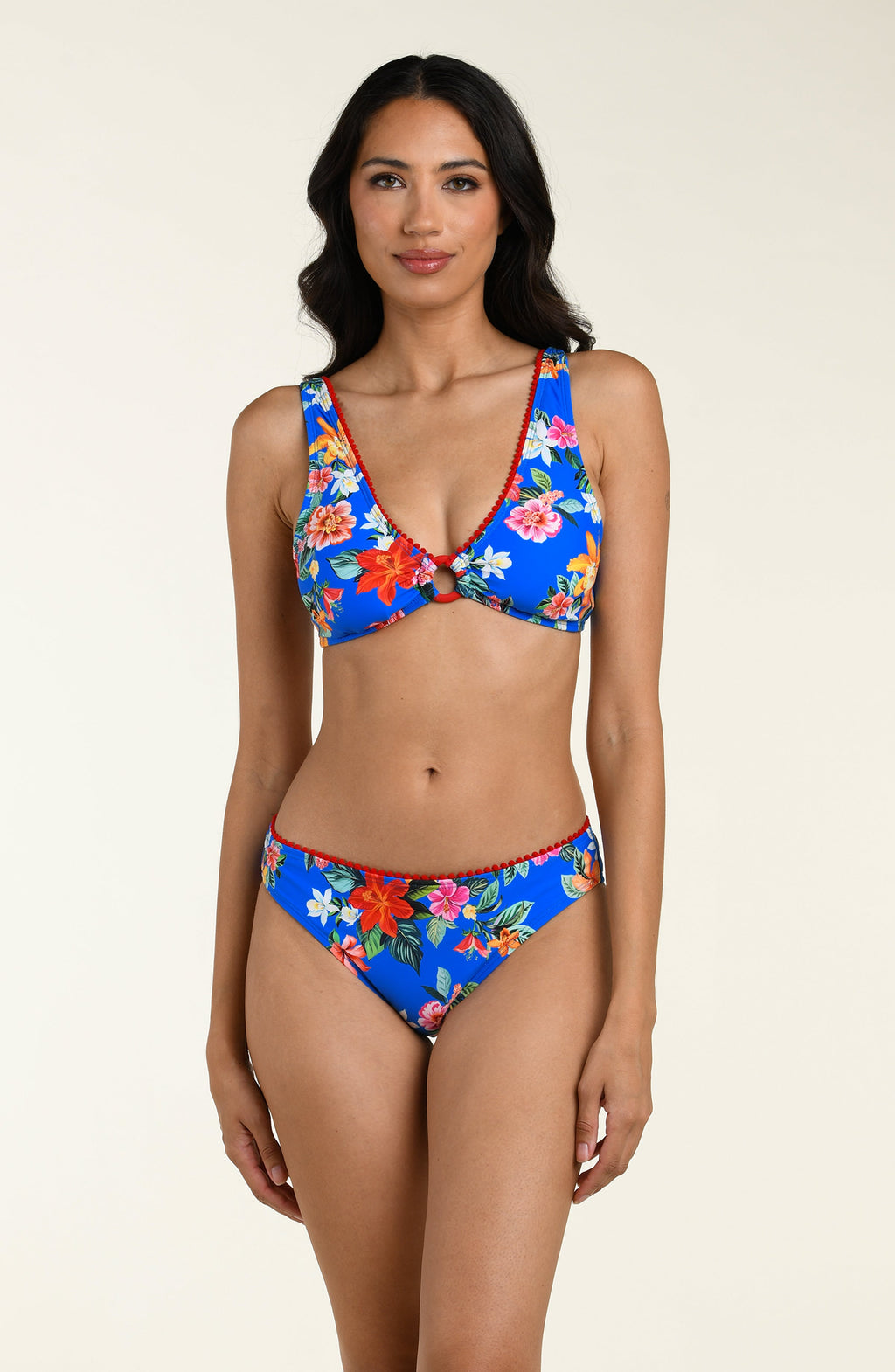 Woman wearing a blue floral bikini top and matching bottom on a beige background