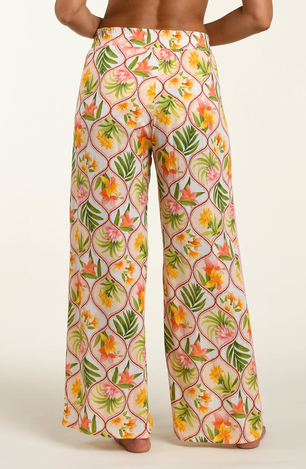 Floral patterned pants worn by a person on a white background