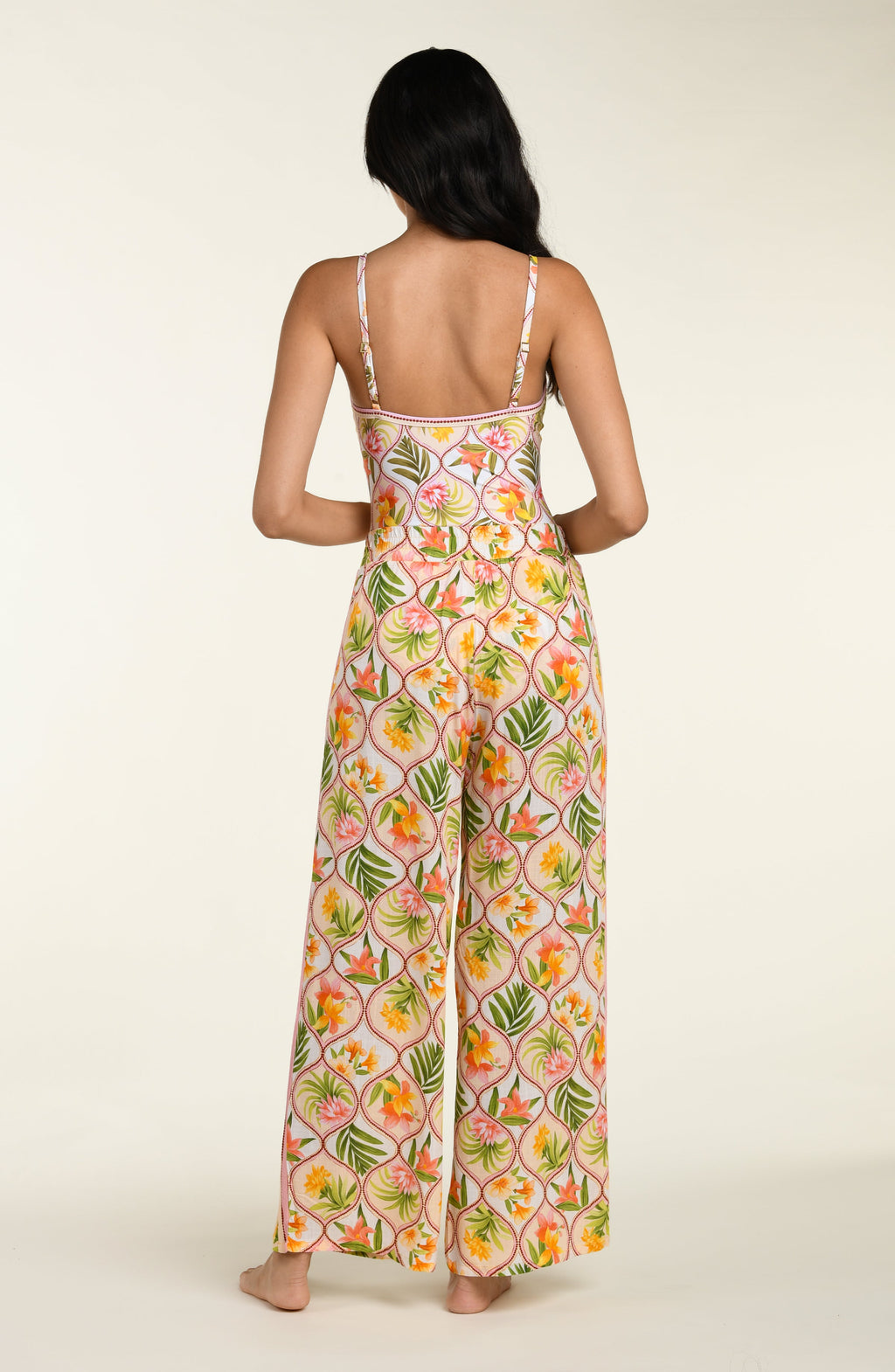Floral patterned pants and matching top worn by a person on a white background