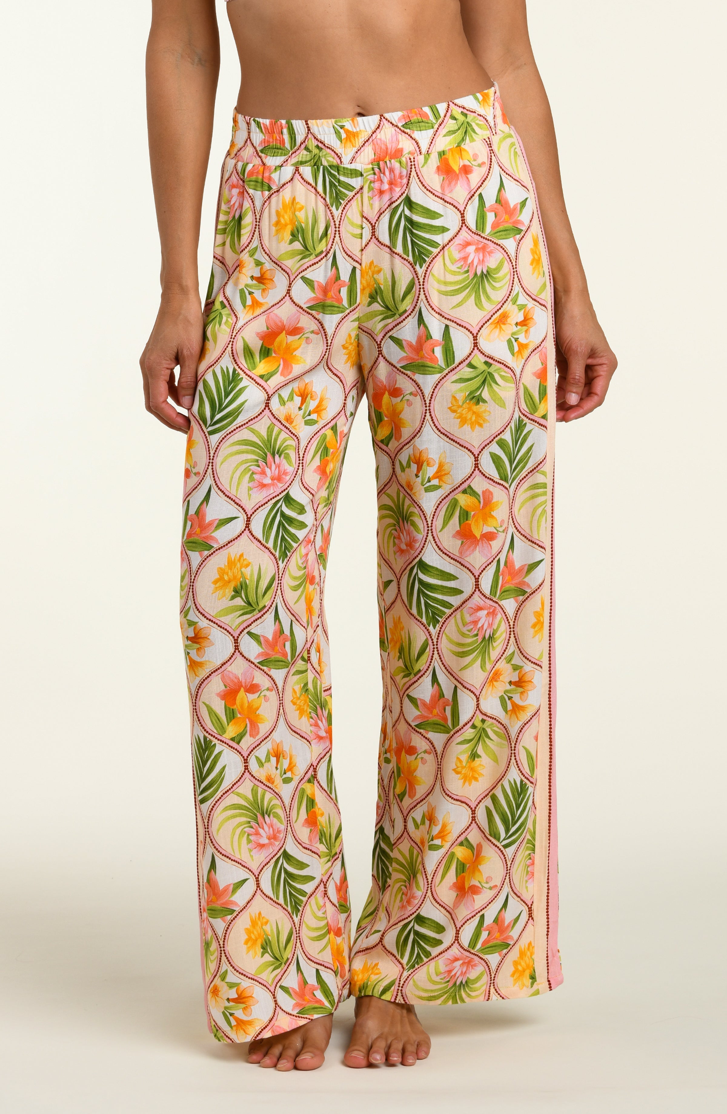 Floral patterned pants worn by a person on a white background