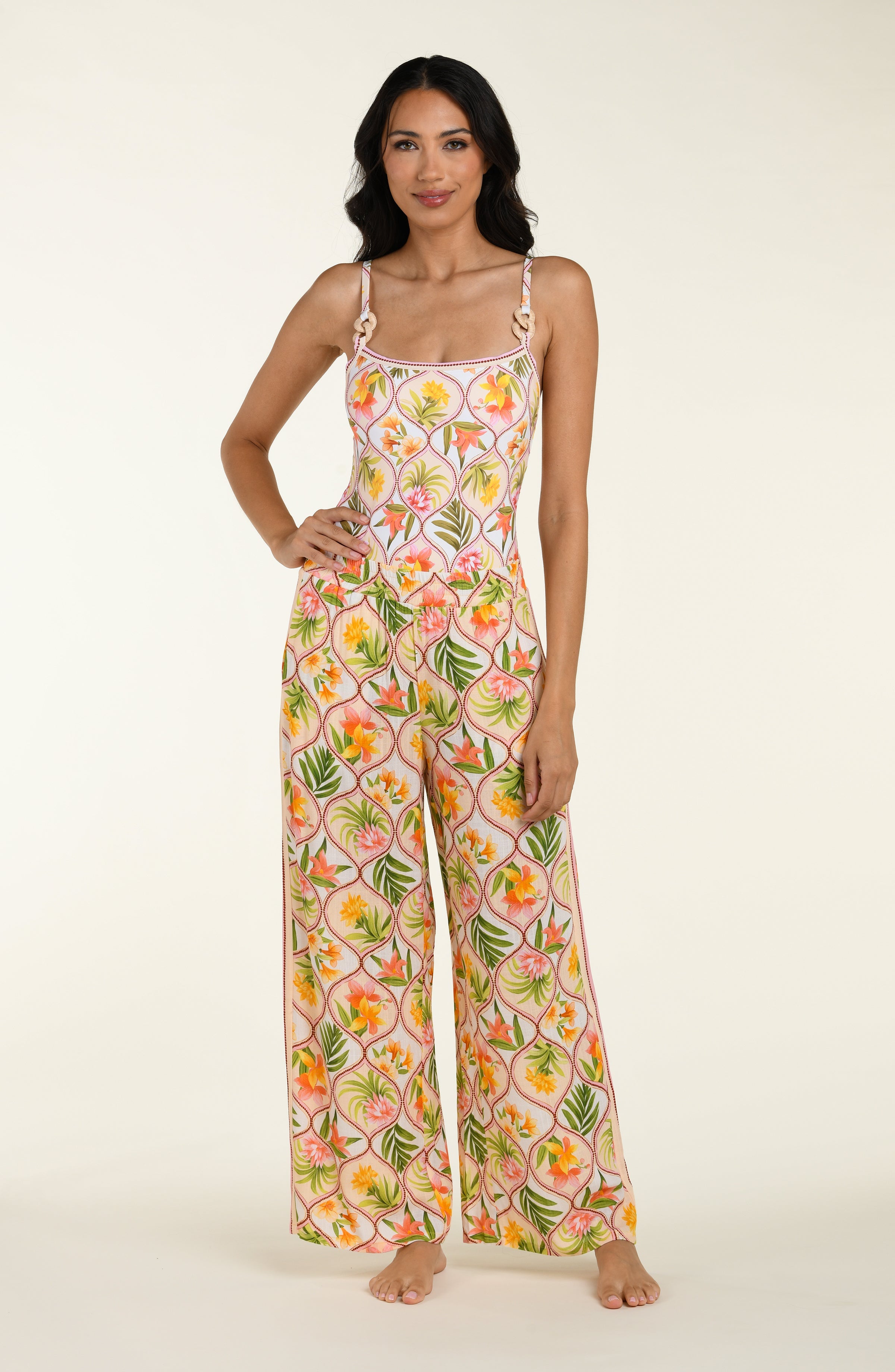 Floral patterned pants and matching top worn by a person on a white background