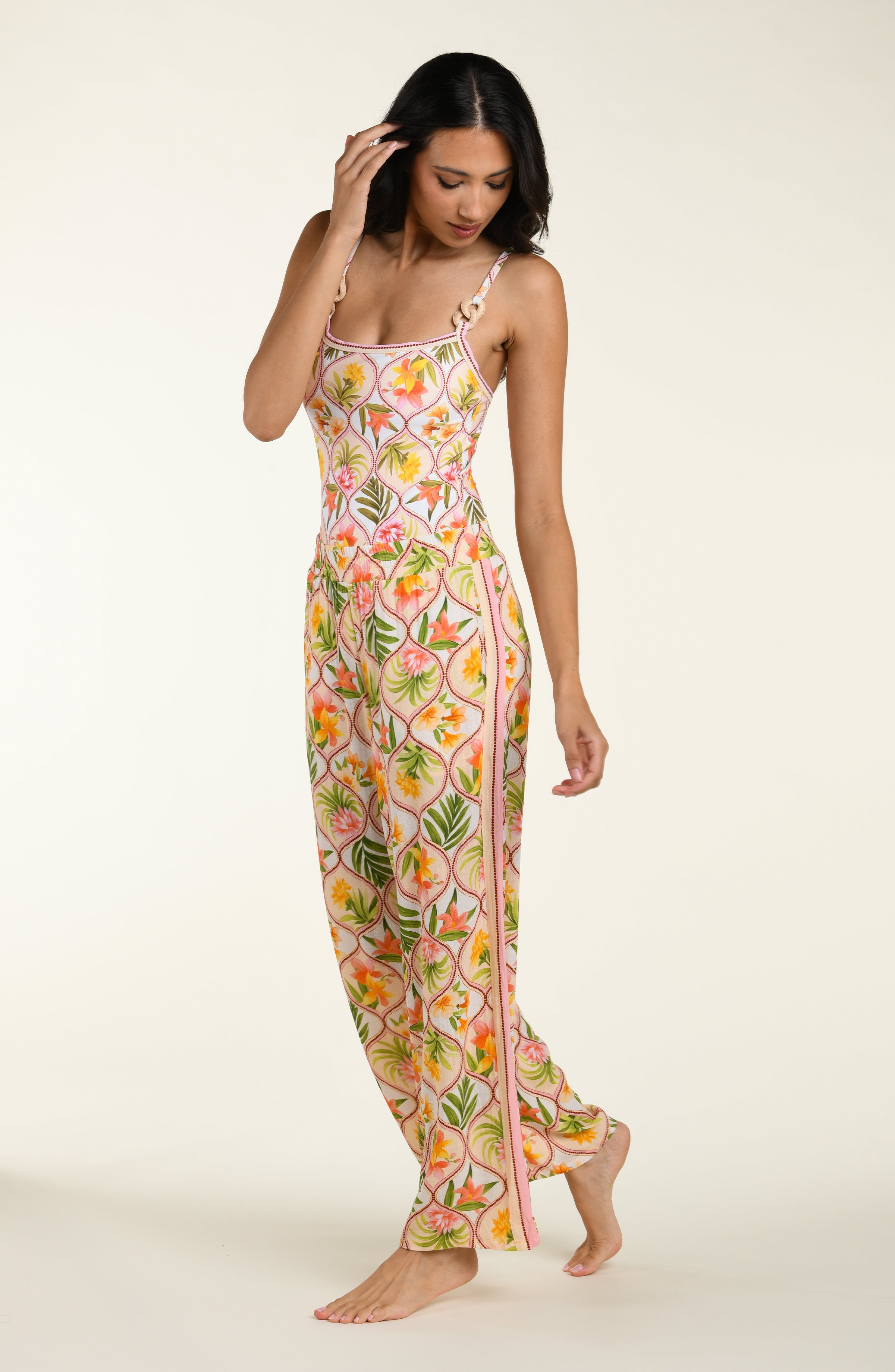 Floral patterned pants and matching top worn by a person on a white background