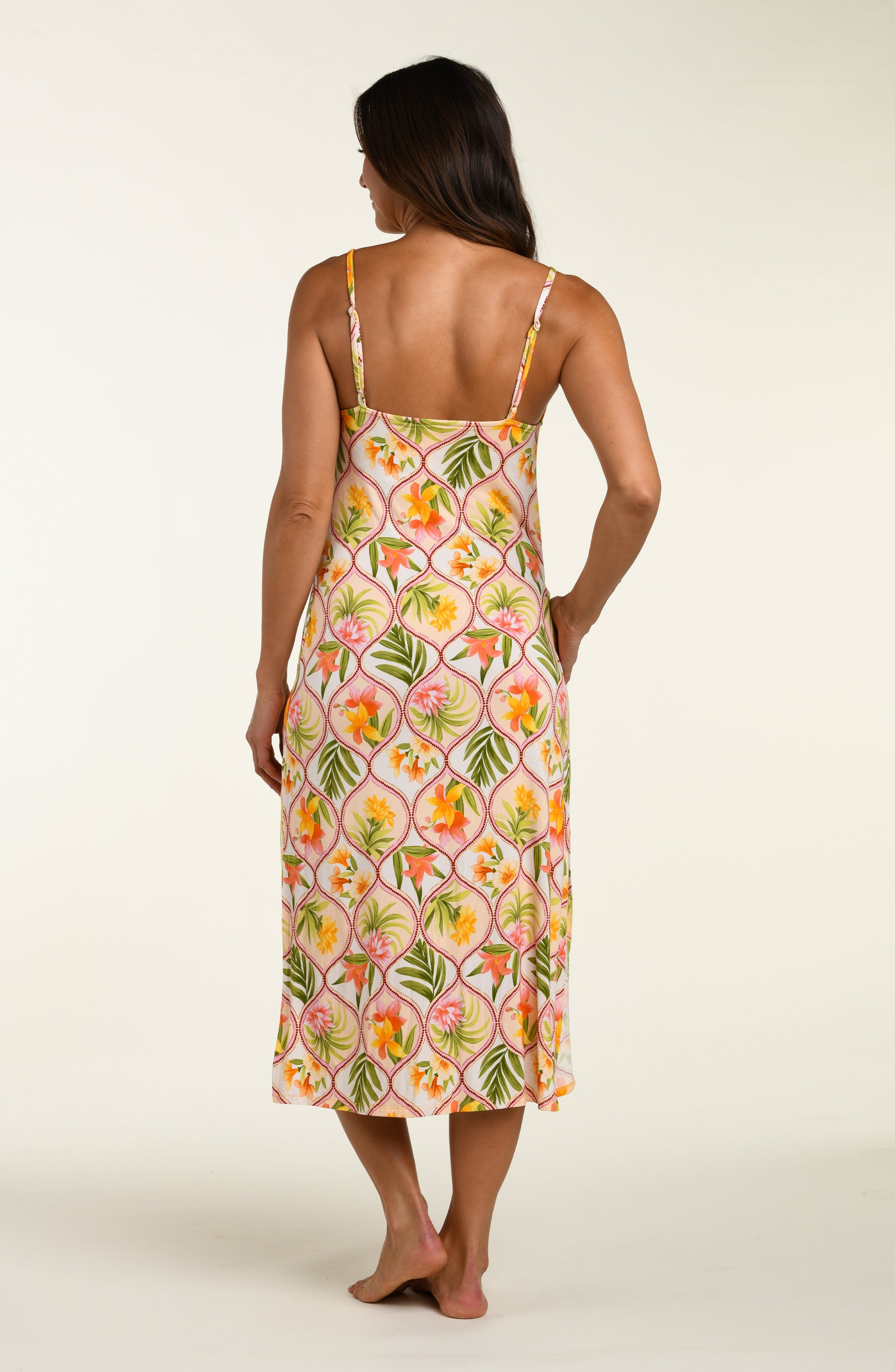 Woman wearing a floral cover up dress on a white background