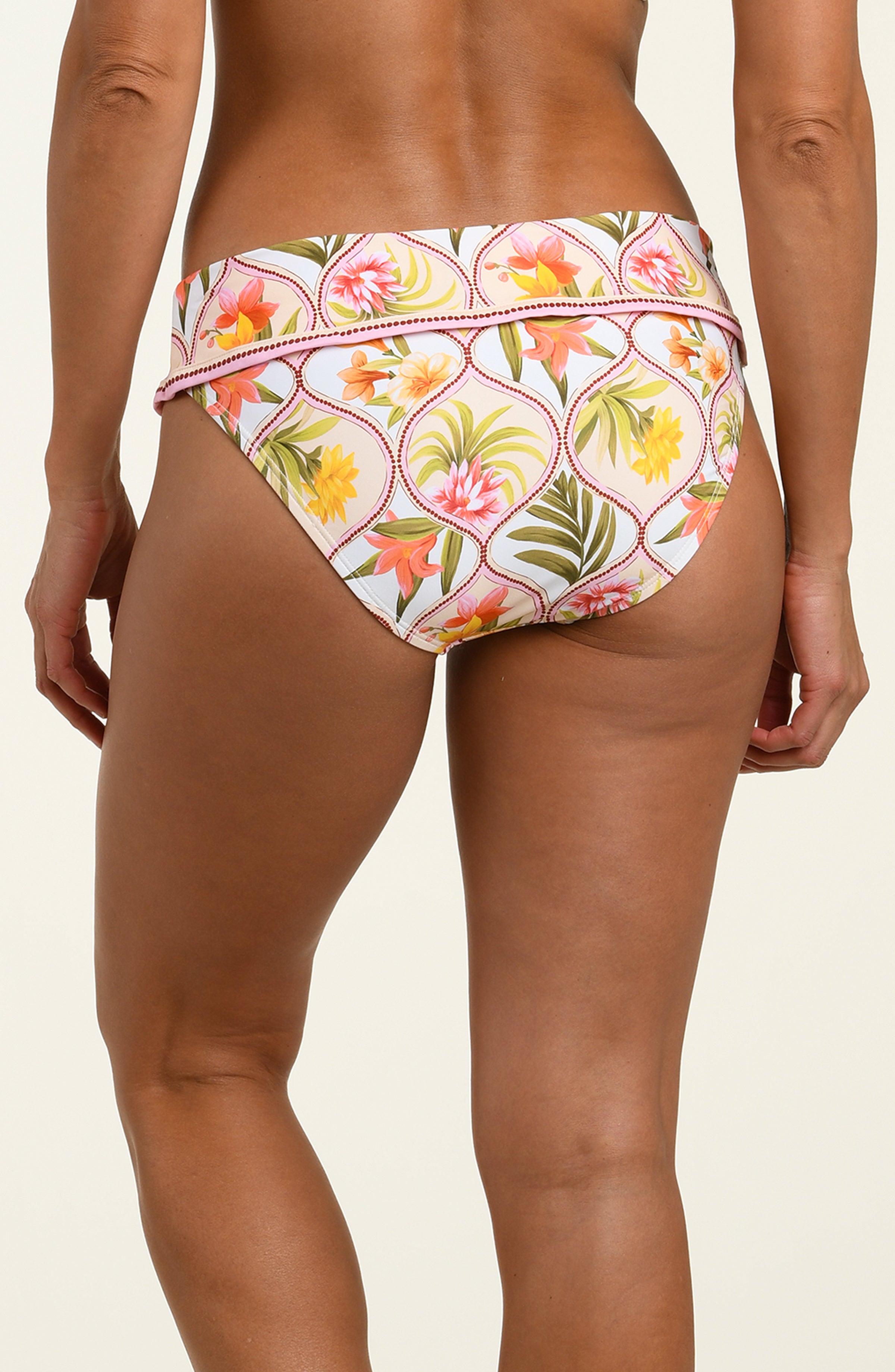 Woman wearing a floral printed bikini bottom against a white background.