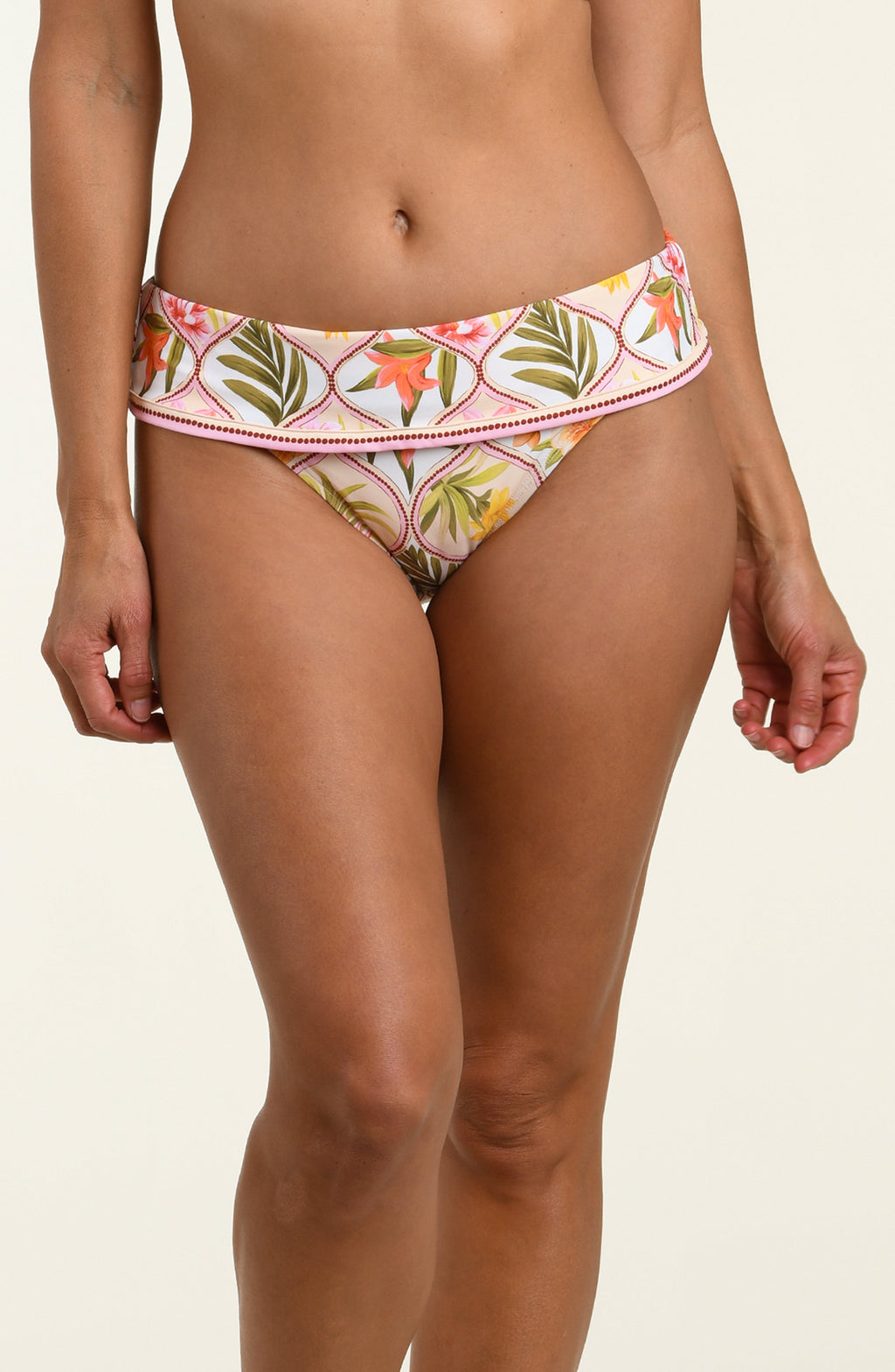 Woman wearing a floral printed bikini bottom against a white background.